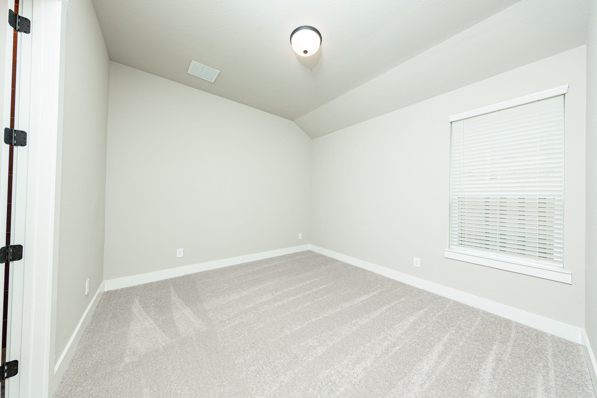 41418 Threadgill Way, Montgomery, TX 77316 This secondary bedroom features a sloped ceiling, plush carpet flooring, a large window, a walk-in closet, and an ensuite secondary bathroom.