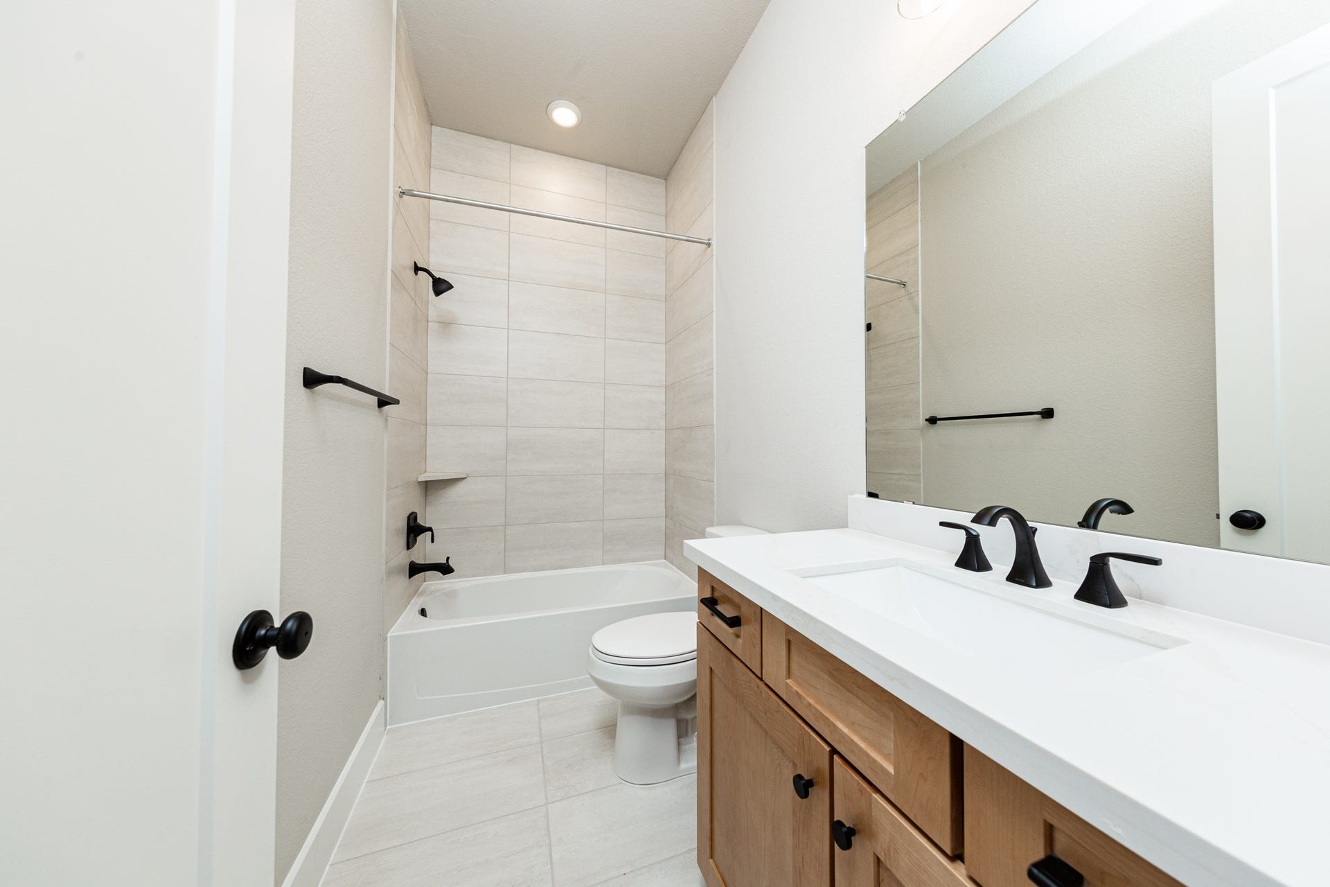 41418 Threadgill Way, Montgomery, TX 77316 This secondary bathroom features a modern vanity, tub/shower combination with gorgeous tile surround, and modern black matte finishes.