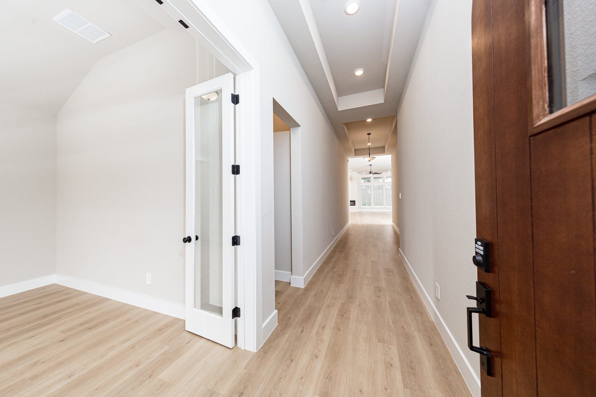 41418 Threadgill Way, Montgomery, TX 77316 An inviting entrance opens up to an open-concept layout, seamlessly connecting the entry to the living areas with durable wood look tile flooring and striking architectural details.