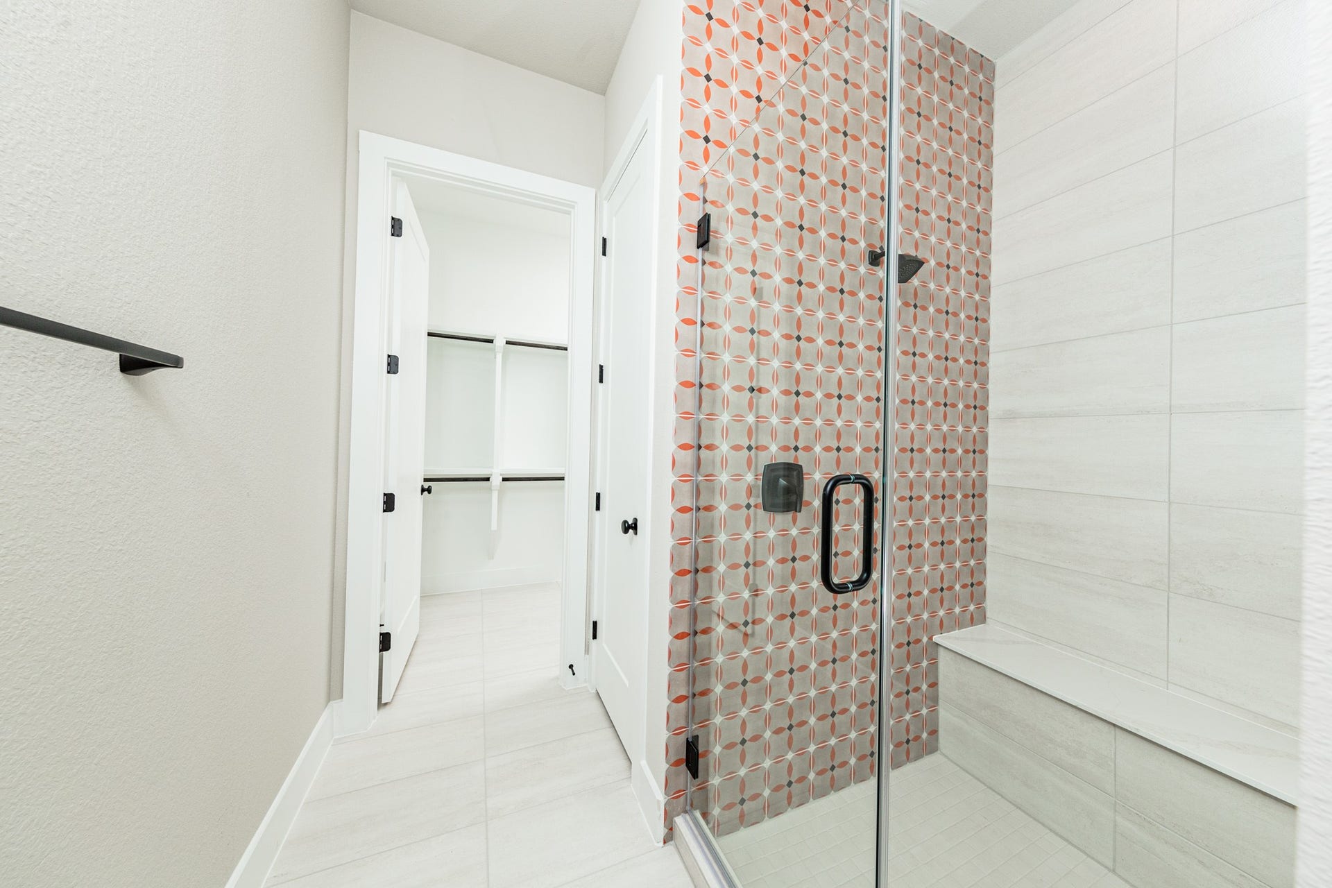 41418 Threadgill Way, Montgomery, TX 77316 The walk-in shower includes a convenient, integrated white bench, offering comfort and a high-end, custom appearance. This modern shower features a striking two-tile design that balances bold patterns with clean, neutral surfaces.