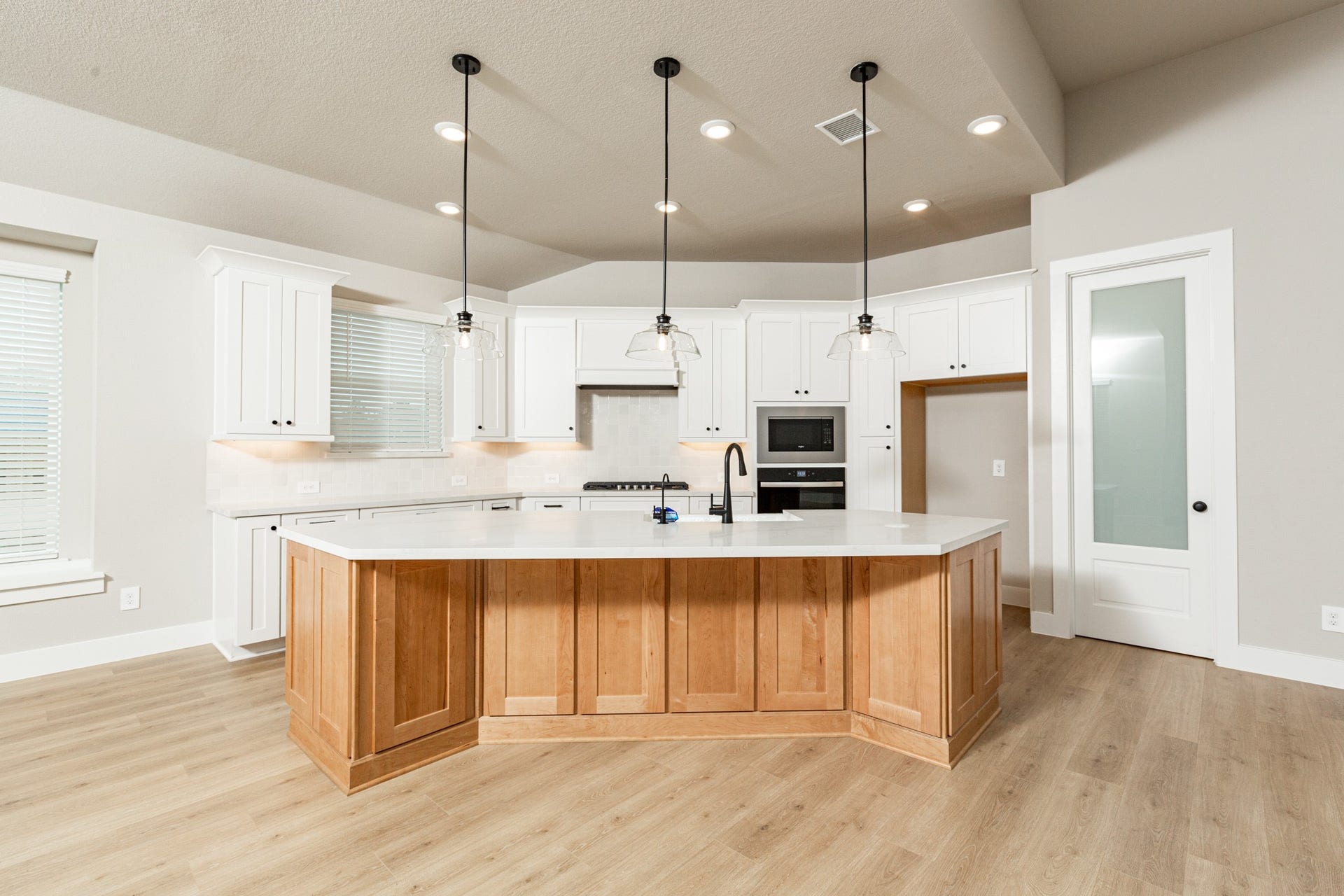 41418 Threadgill Way, Montgomery, TX 77316 The stunning and generously sized center island features a breakfast bar, perfect for casual dining and entertaining. The island is beautifully designed with pristine quartz countertop and elegant pendant lights. The walk-in pantry, with decorative door, is sure to fit all your space needs.