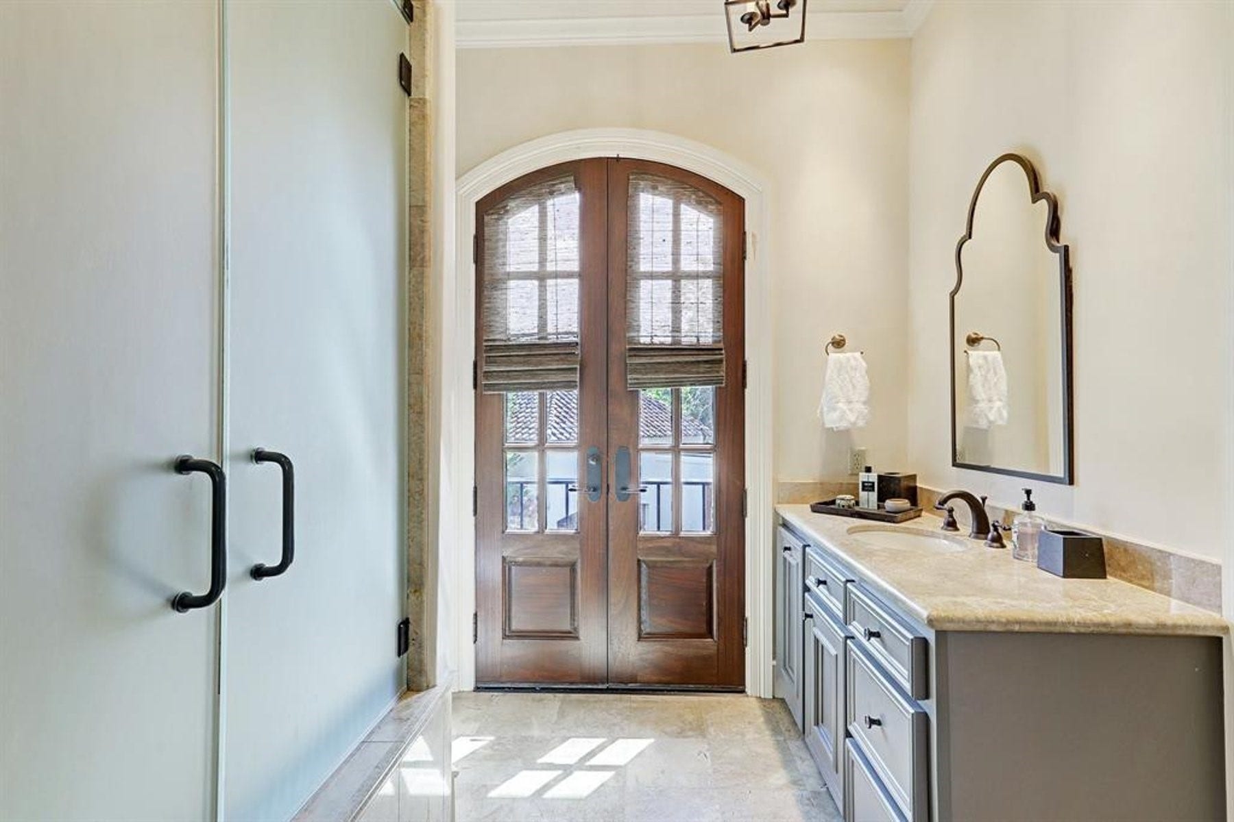 5110 W Oak Mews, Houston, TX 77056 The beautifully appointed second bathroom features elegant marble countertops, a tub/shower combination, and an abundance of natural light. Double doors open to a private balcony overlooking the front of the home, creating a unique indoor-outdoor connection and a charming space to enjoy the neighborhood views.