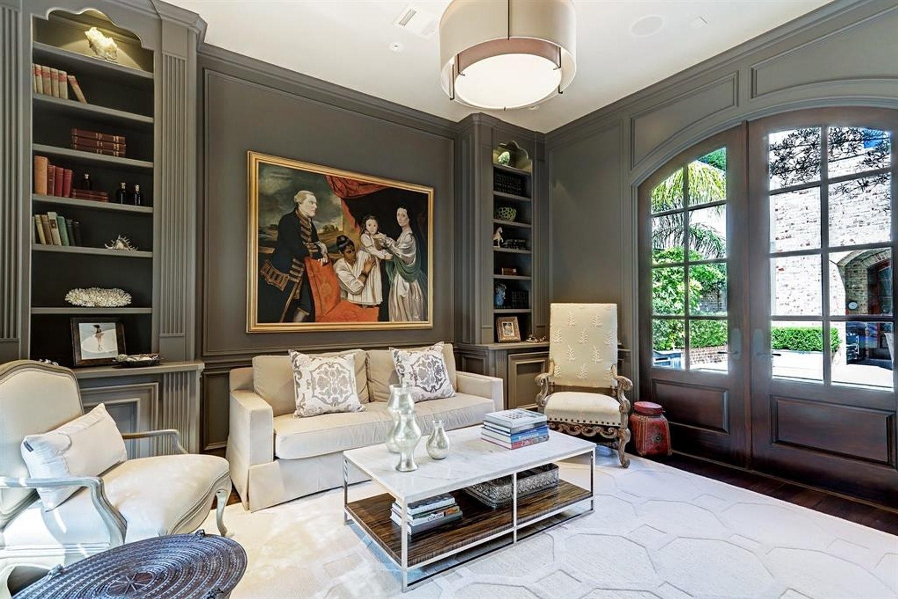5110 W Oak Mews, Houston, TX 77056 Designed for both productivity and inspiration, the elegant study overlooks the tranquil courtyard pool through expansive windows, filling the space with natural light. Rich architectural details are complemented by a refined drum pendant light, creating a sophisticated executive office with a serene, resort-like backdrop.