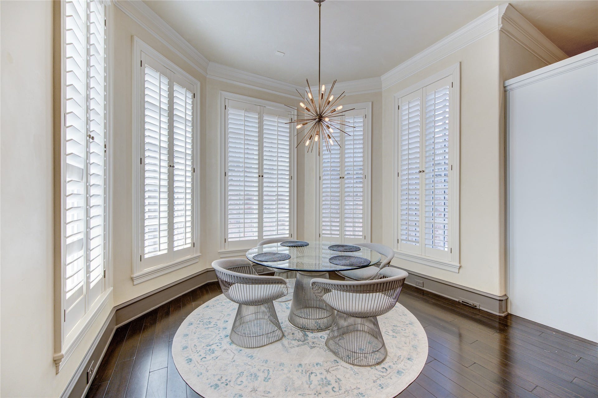 5110 W Oak Mews, Houston, TX 77056 Bathed in natural light, the breakfast room is surrounded by expansive windows adorned with timeless plantation shutters, creating a bright and inviting setting for morning coffee or casual dining. Garden views and abundant sunshine enhance the warm, elegant atmosphere, making this a favorite gathering space throughout the day.