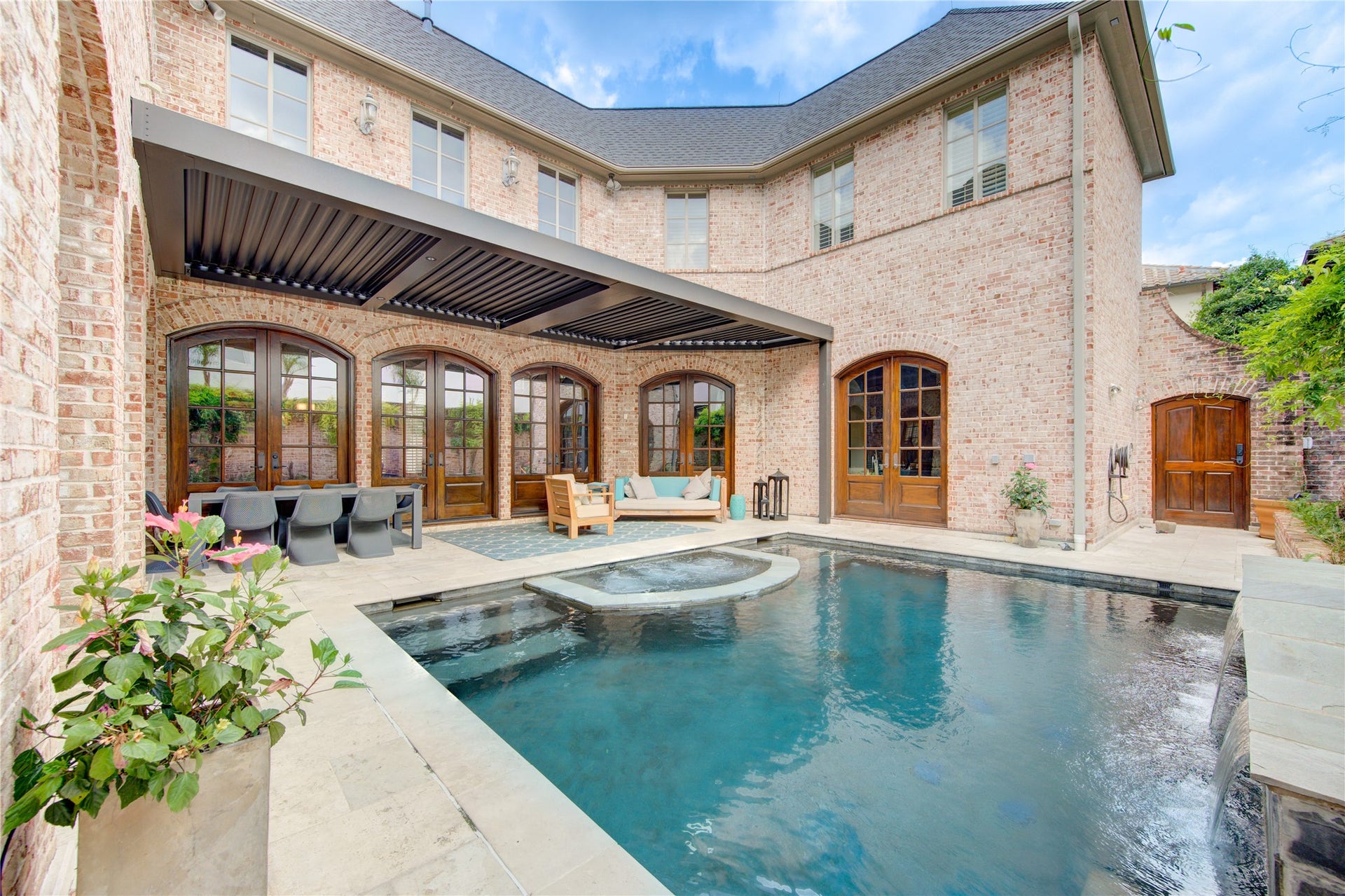 5110 W Oak Mews, Houston, TX 77056 Your own private resort awaits in the spectacular courtyard, where the sparkling pool is crowned by an innovative motorized metal pergola with smart controls. At the touch of a button, the adjustable louvers open to welcome the sunshine or close for shade and comfort, while integrated lighting creates the perfect evening ambiance. A built-in rain sensor automatically closes the system when needed, delivering a seamless blend of luxury, technology, and year-round outdoor living.