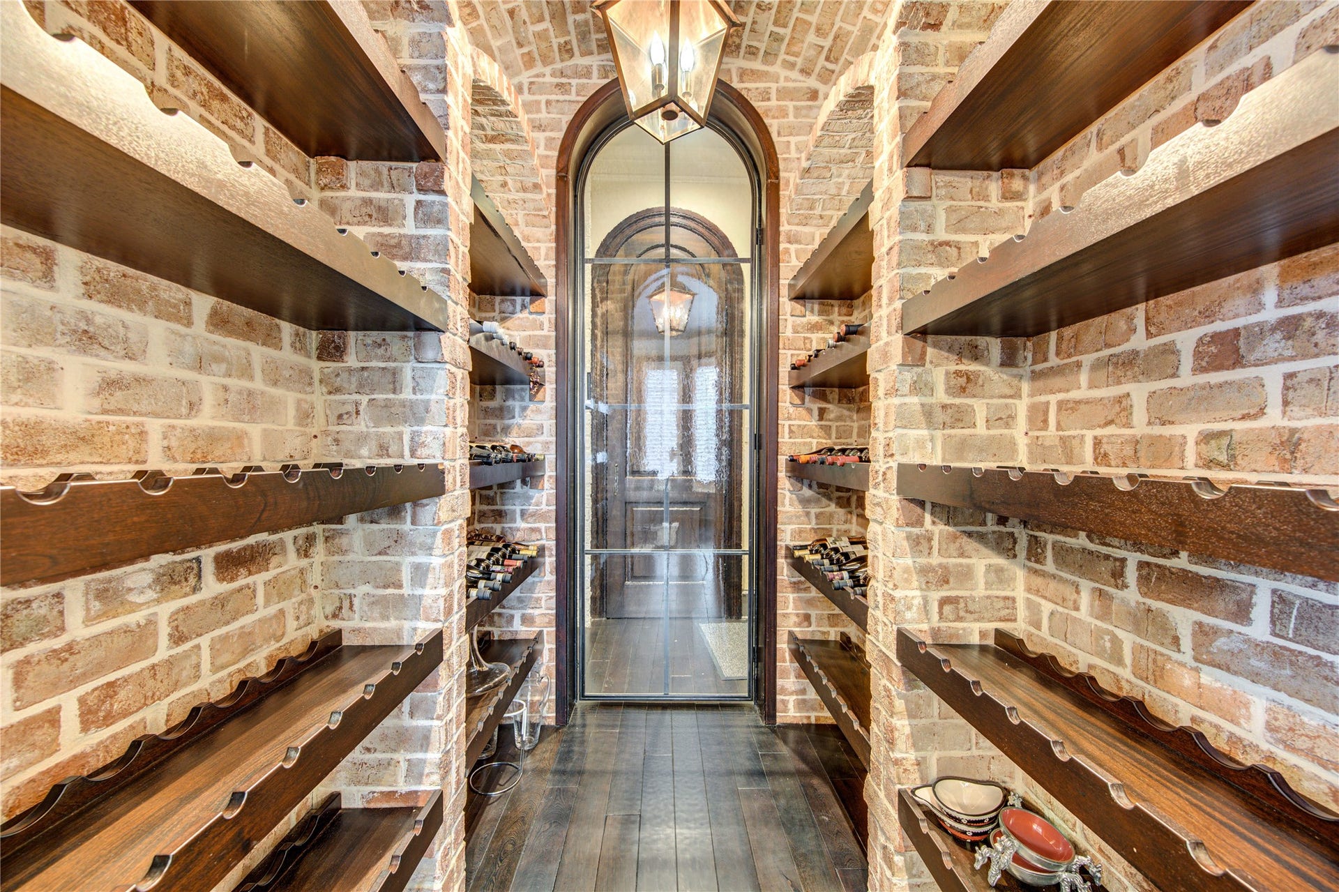 5110 W Oak Mews, Houston, TX 77056 This gorgeous wine vault encased with brick walls is the perfect place to store your vast wine collection and offers a pass through to the kitchen.