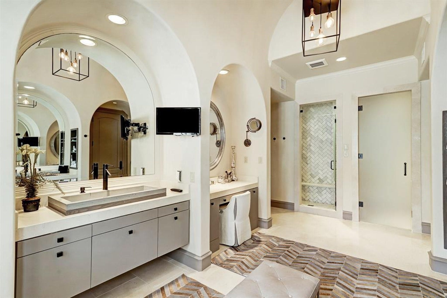 5110 W Oak Mews, Houston, TX 77056 The spa-inspired primary bath continues with an oversized walk-in shower, a dedicated makeup vanity, and striking statement pendant lighting that elevates the space with designer flair. Every detail has been thoughtfully selected to create a luxurious retreat that blends modern sophistication with everyday functionality.