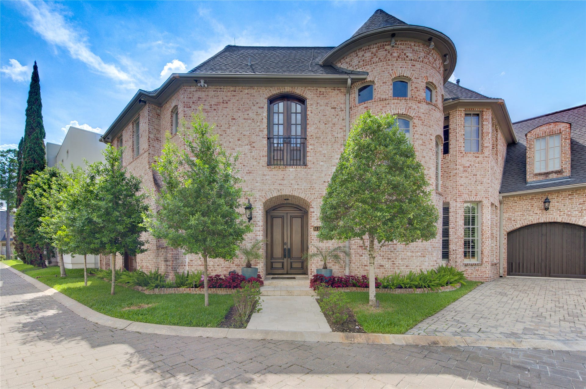 5110 W Oak Mews, Houston, TX 77056 Gracefully positioned on a quiet cul-de-sac, this distinguished residence showcases a timeless brick exterior accented by classic gas lanterns that create a warm, welcoming first impression. A spacious three-car garage and exceptional architectural design enhance the home's stately curb appeal, reflecting the elegance and craftsmanship found throughout this remarkable property.