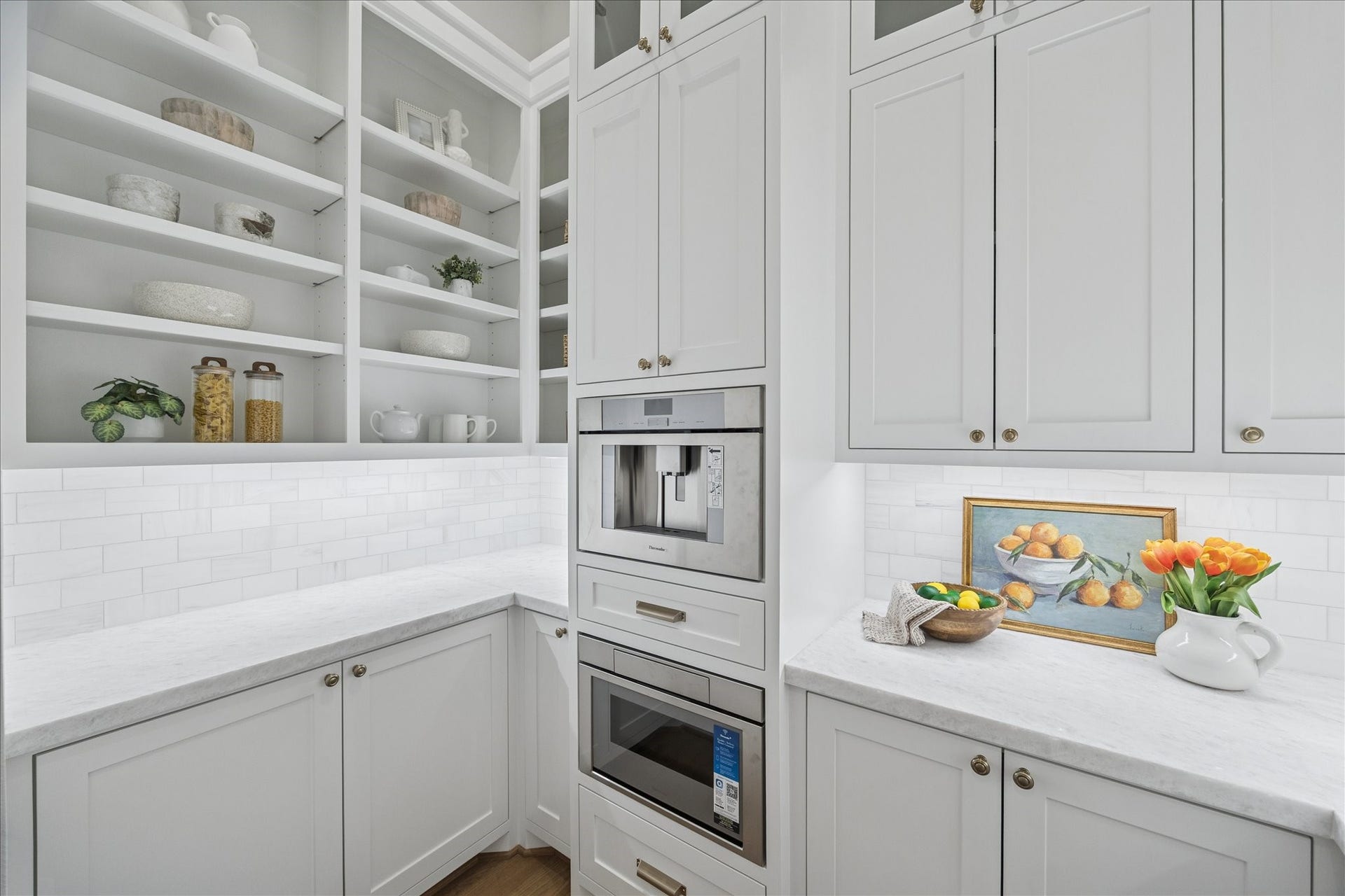 Tucked behind the main kitchen, an integrated prep zone features a panel-ready refrigerator, built-in coffee system, microwave, and extensive storage. This secondary workspace enhances entertaining efficiency while maintaining the clean, gallery-like aesthetic of the front kitchen. *Previous Project*