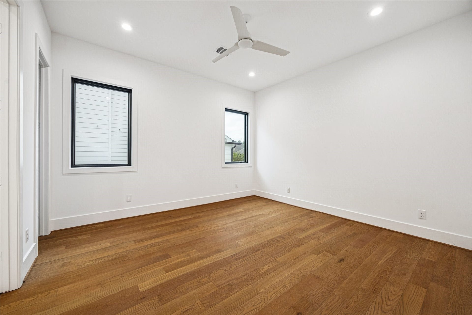 Crisp architectural lines define this bedroom, highlighted by wide plank hardwoods, Pella windows, and tall 8 foot interior doors with Emtek hardware. The generous layout supports multiple configurations with a naturally elevated feel. *Previous Project*