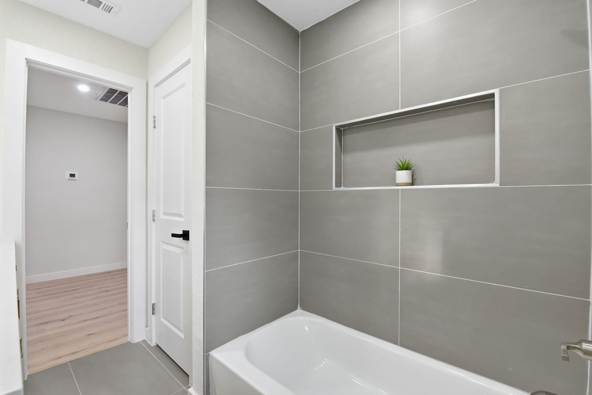 1011 Sycamore Road, Richmond, TX 77469 Hall bathroom linen closet and bathtub with large format tile surround