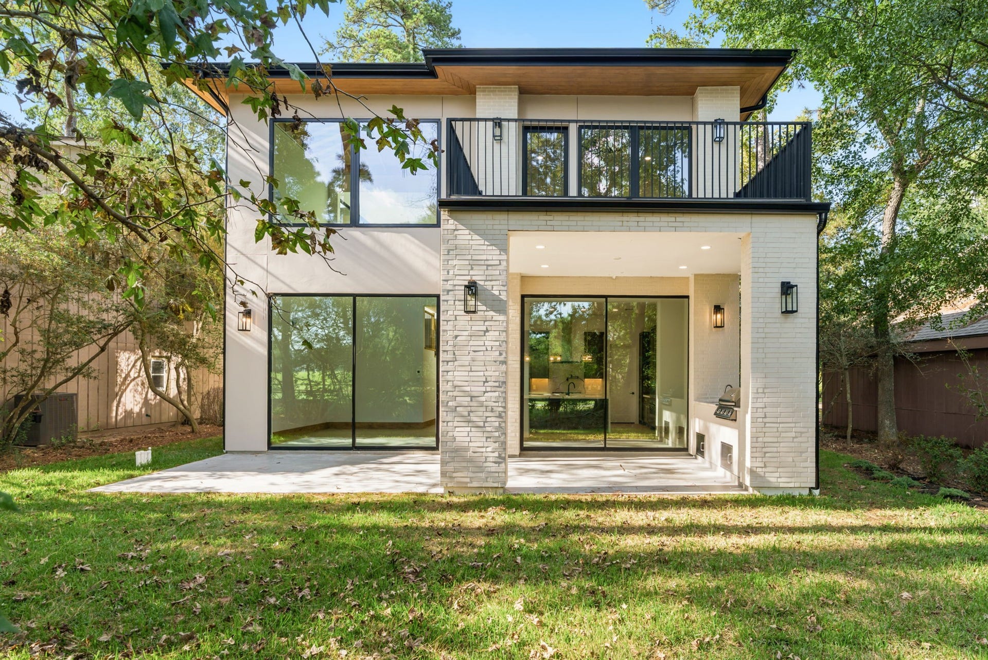 12 N Timber Top Dr, Spring, TX 77380 Stunning rear exterior featuring a covered patio with a fully equipped outdoor kitchen, built-in grill, and prep sink.