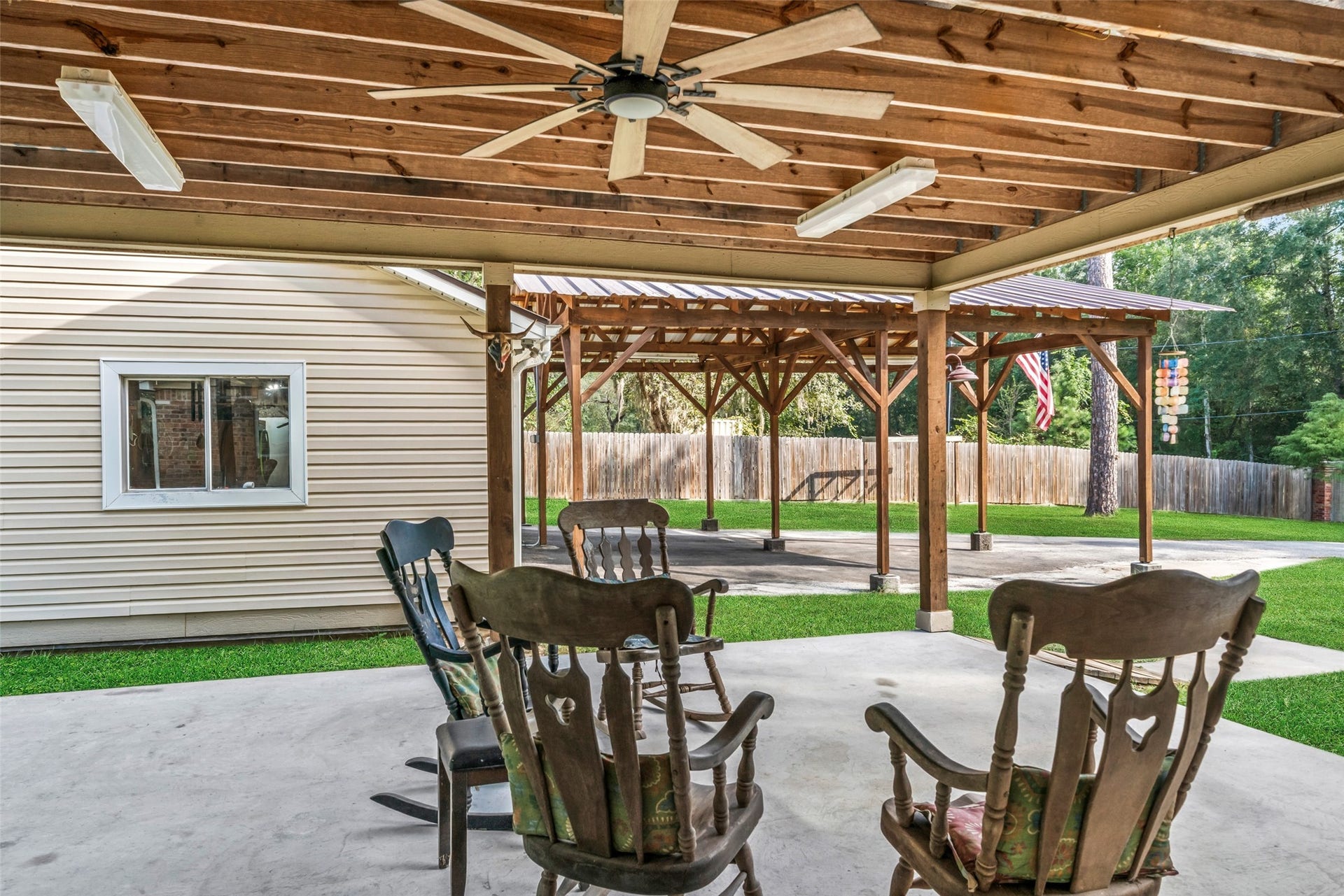 Sometimes, the best spaces aren't inside the house, but right outside the door. This is the kind of space that invites you to slow down, sit a spell, and let your mind wander. A peaceful place to enjoy your morning beverage, gather with family and friends, or simply sit back and enjoy the quiet. The covered carport offers so much more than parking, creating an extended outdoor living space with plenty of room to entertain, relax, and make memories.