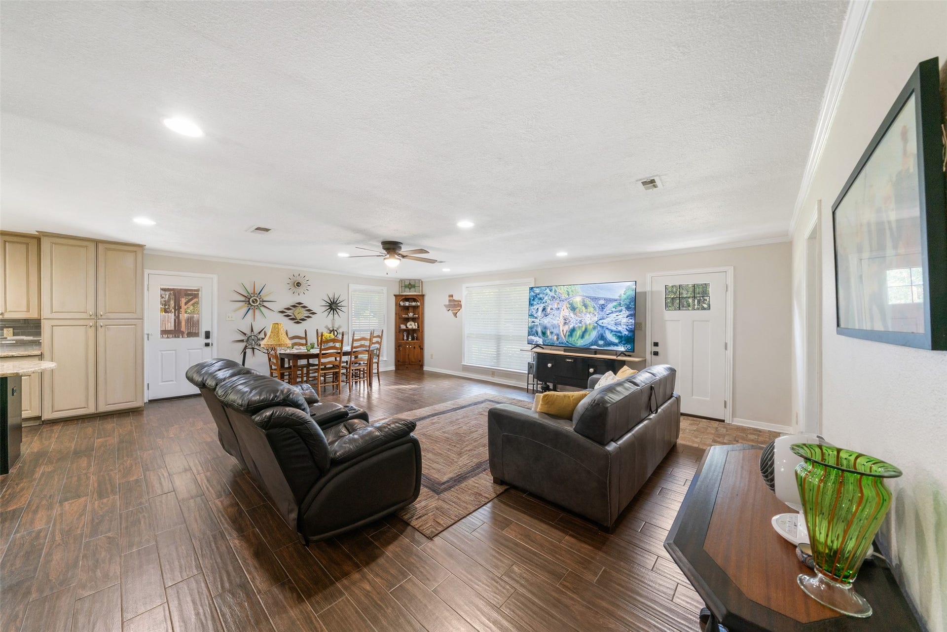 Another beautiful angle of this living and dining space, it truly shines from every viewpoint. The picturesque windows pour in natural light, enhancing the warm, open feel of the room. The new front door with its window inset adds a welcoming touch the moment you step inside, tying perfectly into the bright, airy flow of the home.