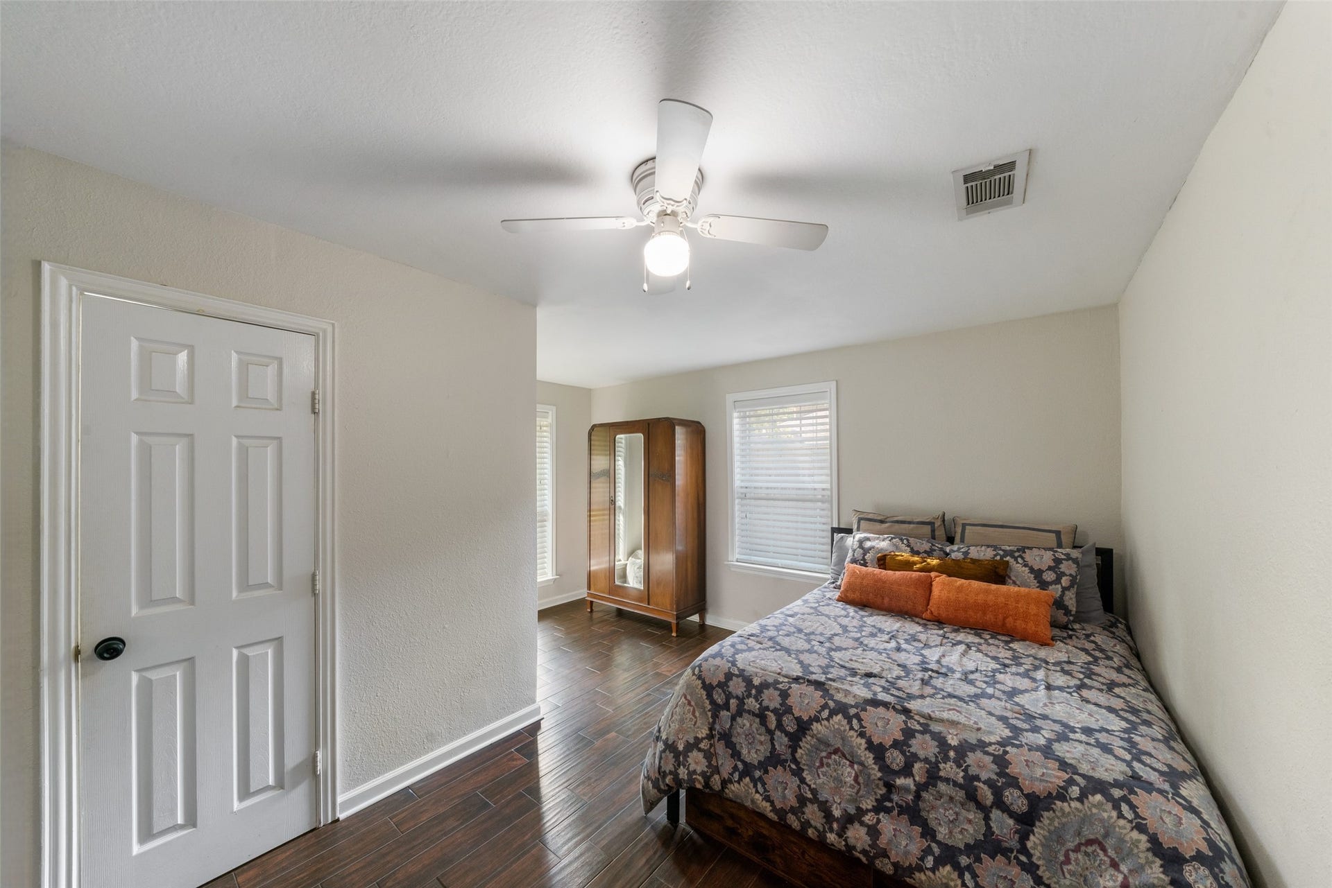 This secondary bedroom offers neutral paint and beautiful wood-plank tile flooring, with windows that bring in plenty of natural light. It has access to a full secondary bathroom with a tub/shower combo, the room has a small closet, the area currently used for an armoire provides additional storage options. More closet space needed it can easily be enclosed to create a walk-in closet if desired. Whether you need a study, a flex room, or space for bunk beds in a kids room, this bedroom is versatile.