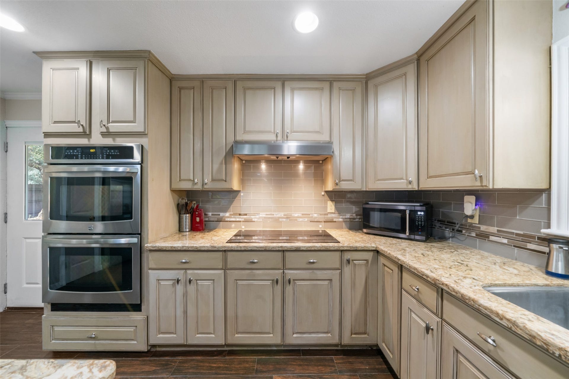 This custom kitchen features stainless steel electric convection ovens, an induction cooktop, and a heavy-duty stainless steel vent hood with excellent lighting, just a few of the impressive updates that elevate both the style and functionality of this space. Every detail reflects quality and thoughtful design.