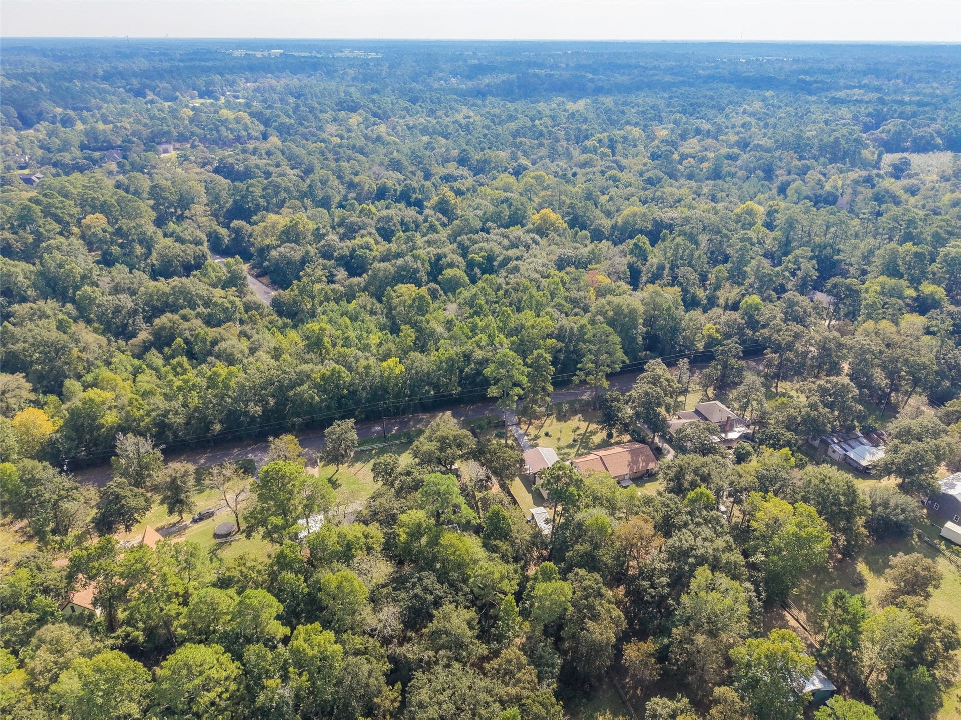 Another amazing view of this awesome property. You can see an open and spacious front yard, while having a canopy of trees covering your back yard. This property is deep as you can see the roof top of the barn in the back corner just to show how far back it sits from the house.