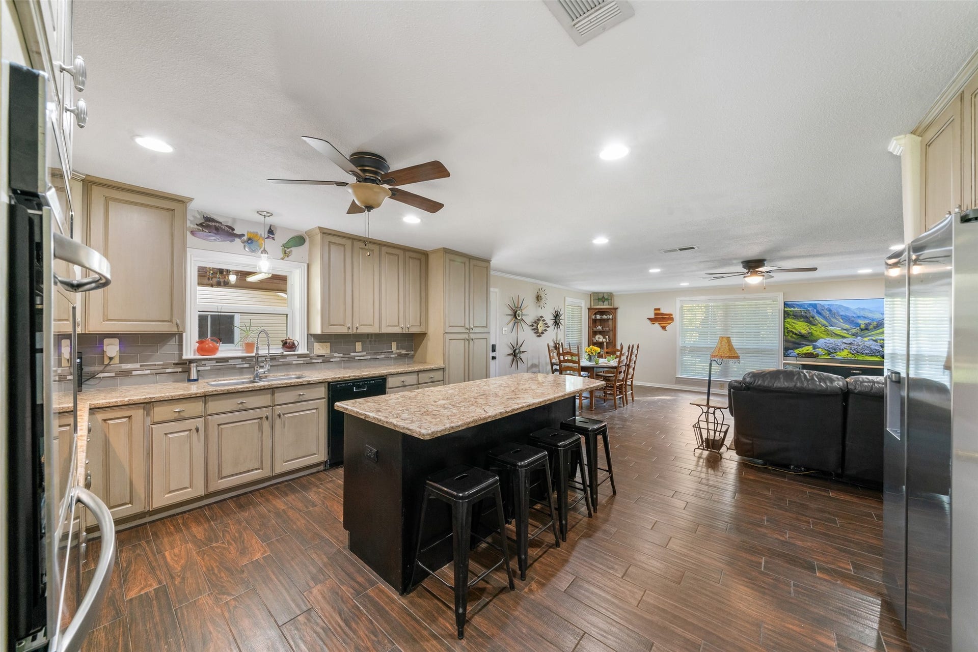 This space is bright, open, and wonderfully connected. The recessed lighting provides clean, even illumination throughout, while the natural light pouring in from multiple windows adds warmth and makes the entire area feel inviting. The open flow from the kitchen into the dining and living areas creates a seamless layout thats perfect for everyday living and entertaining.