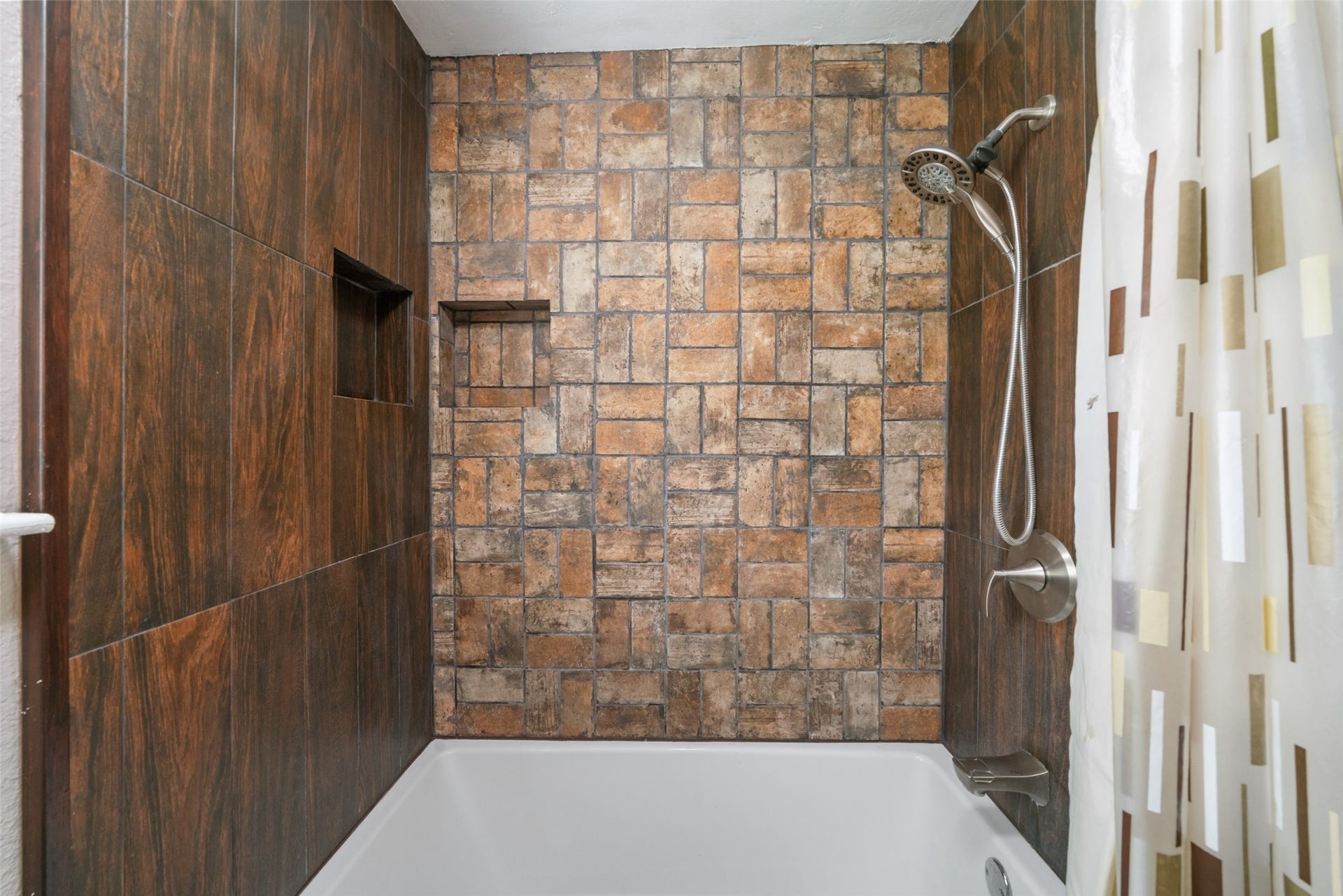 This updated secondary bath is beautifully finished and feels fresh and modern. It features a deep soaker tub thats perfect for unwinding, along with newly updated PEX plumbing in the shower for long-term reliability and peace of mind. The tile selections and built-in niches give the space a stylish, functional look, making this bathroom a standout among the homes recent upgrades.