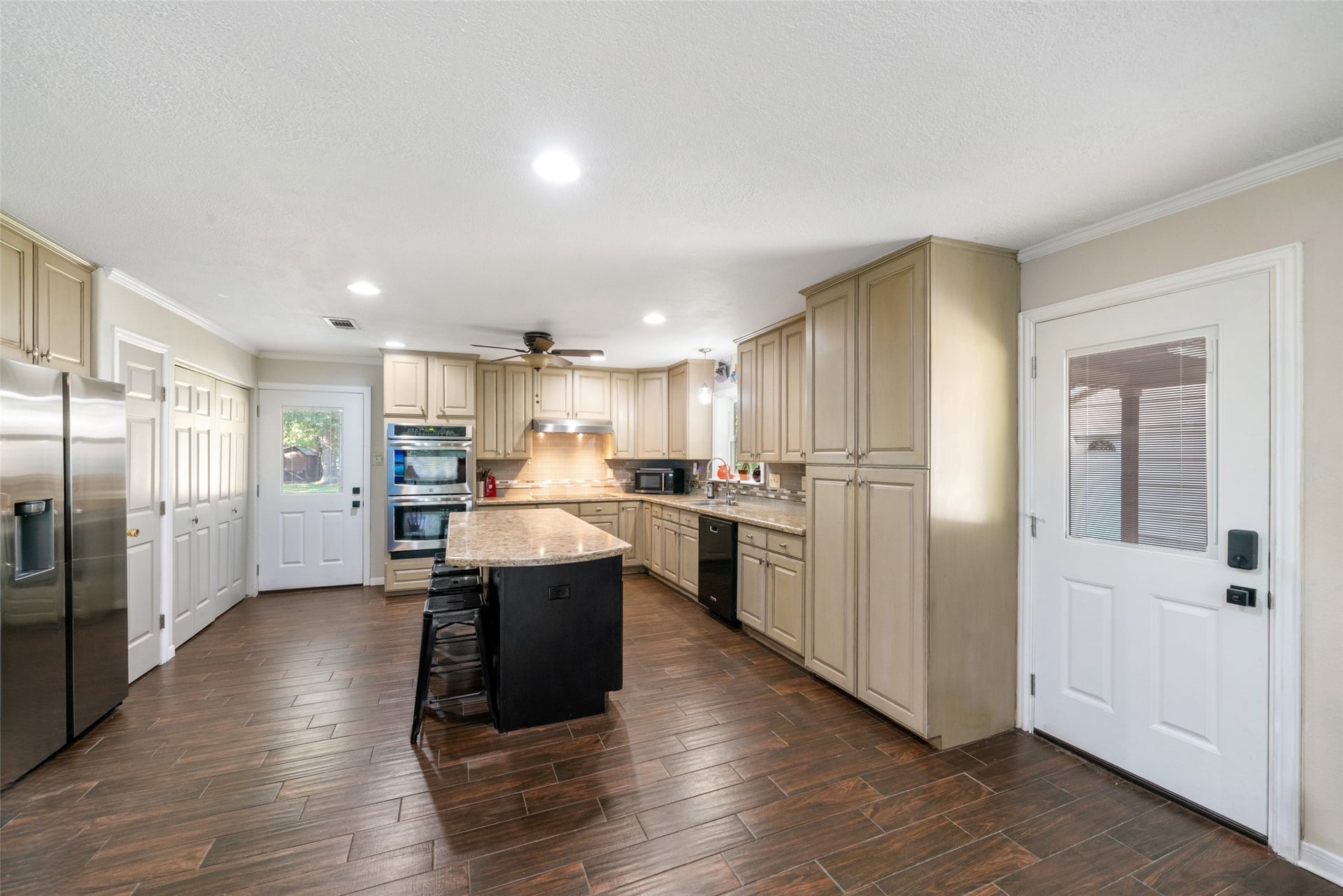 This kitchen immediately welcomes you the moment you step in from the covered patio. Its open, warm, and truly the heart of the home. Over $50,000 was invested in remodeling this space, and it shows in every detail. The layout offers incredible room to move, cook, gather, and entertain, all while staying visually connected to the surrounding living areas. The new exterior doors add both style and efficiency, completing a kitchen that feels fresh, spacious, and designed for everyday living.