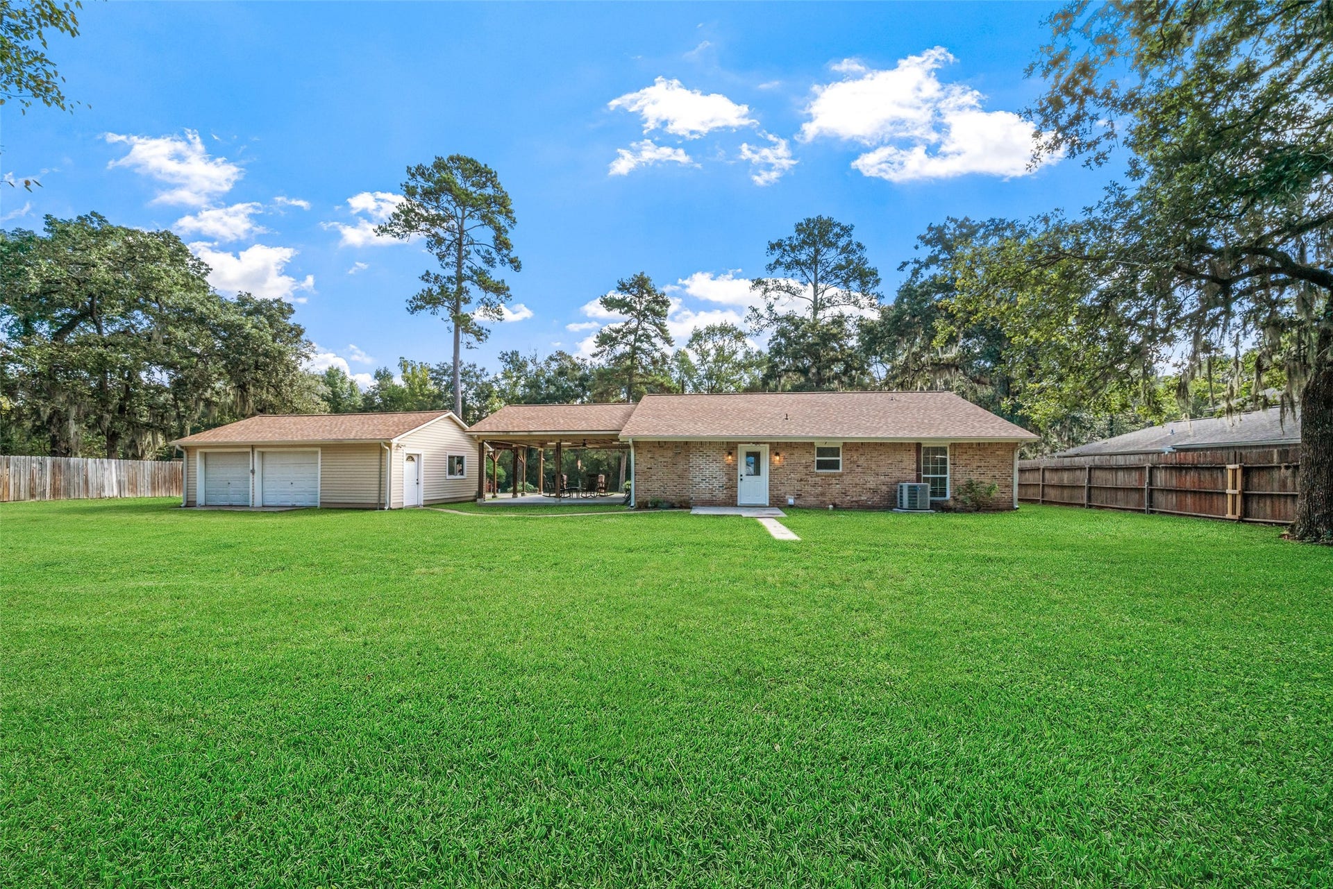 This all-brick home is complete with gutters and a detached garage finished in vinyl siding. The attached covered patio is a true bonus and is easily a favorite spot for relaxing views of both the front and backyard. The backyard is spacious with a wide, open expanse of green space with plenty of room to play, garden, or even add a future pool if desired. Towering trees and gorgeous skies surround this peaceful country property for everyday enjoyment. (all backyard grass, has photo enhancements)