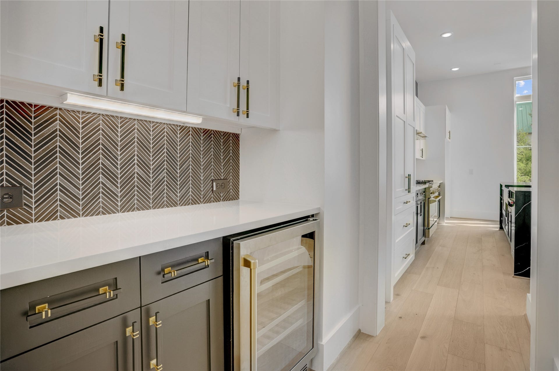 1907 Lauderdale Street, Houston, TX 77030 The butler's pantry divides the kitchen and dining and features a dry bar area with a wine fridge and additional storage space. Virtually staged photo.
