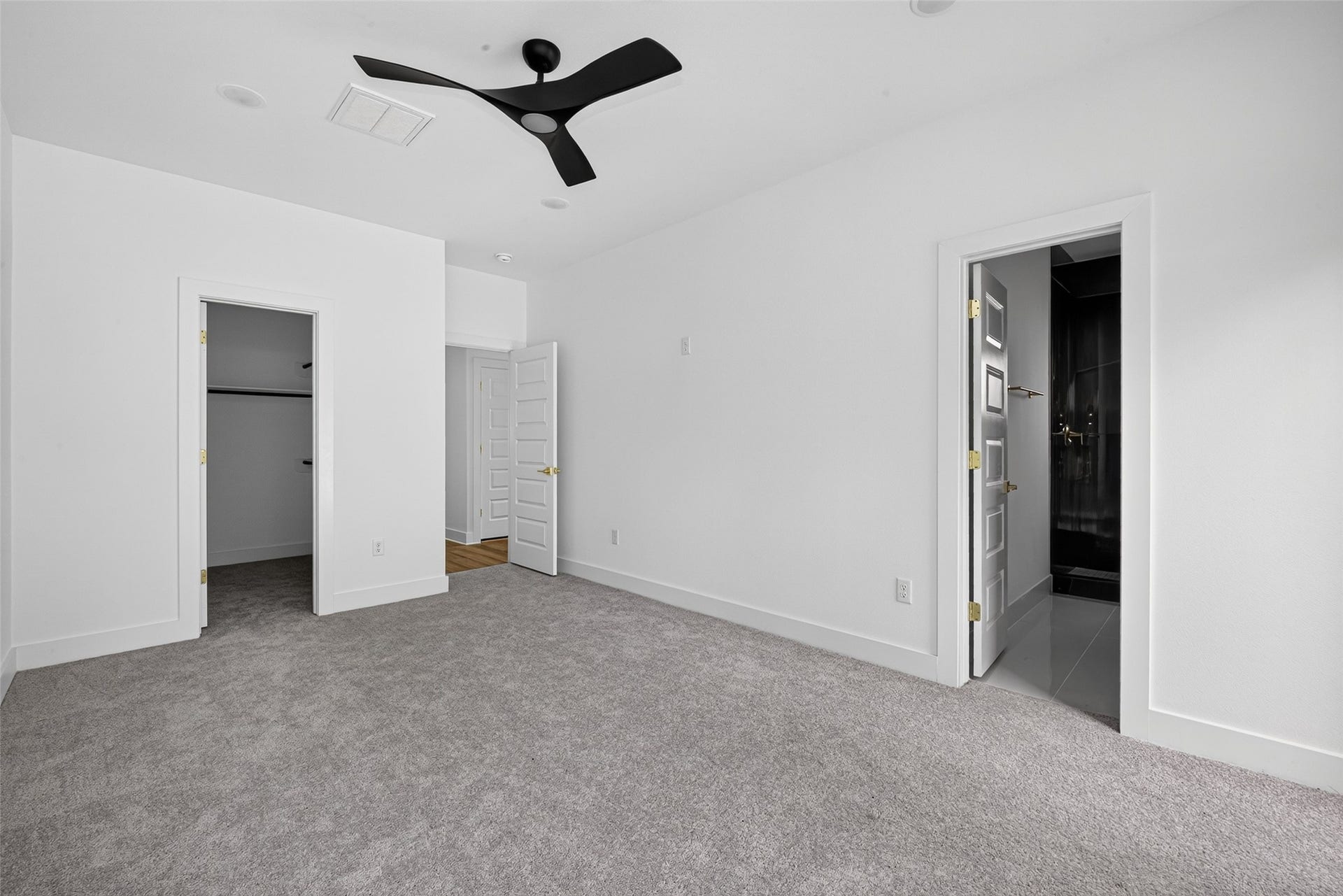 9309 Caddo Road, #A/B, Houston, TX 77078 Generous layout highlighted by a black designer ceiling fan, leading directly into a grand walk-in closet and a private, spa-inspired en-suite bath.