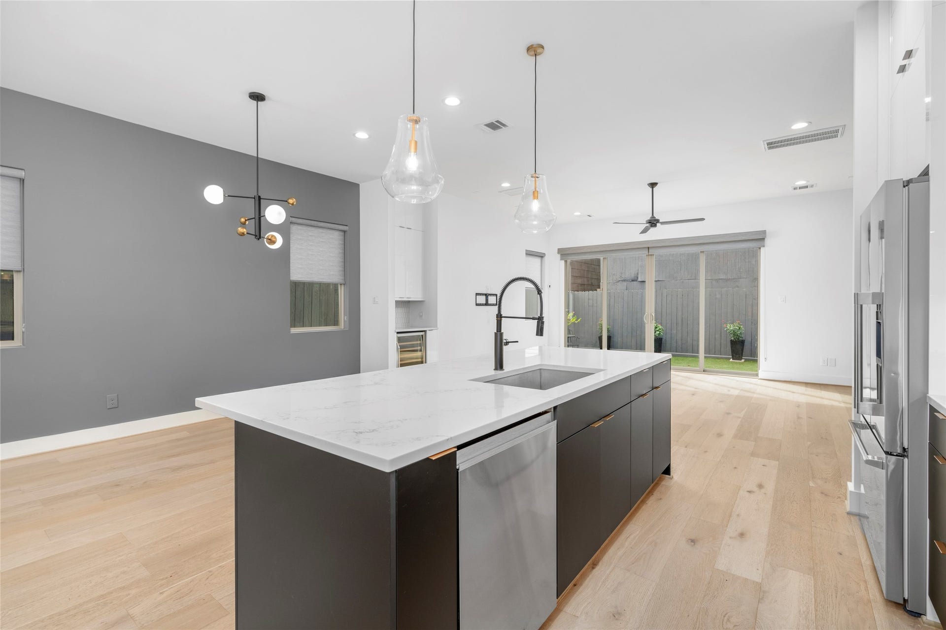 2410 Elmen Street, Houston, TX 77019 Kitchen with views of the dining room and living room beyond. Fisher & Paykel dishwasher conveniently located in the island.