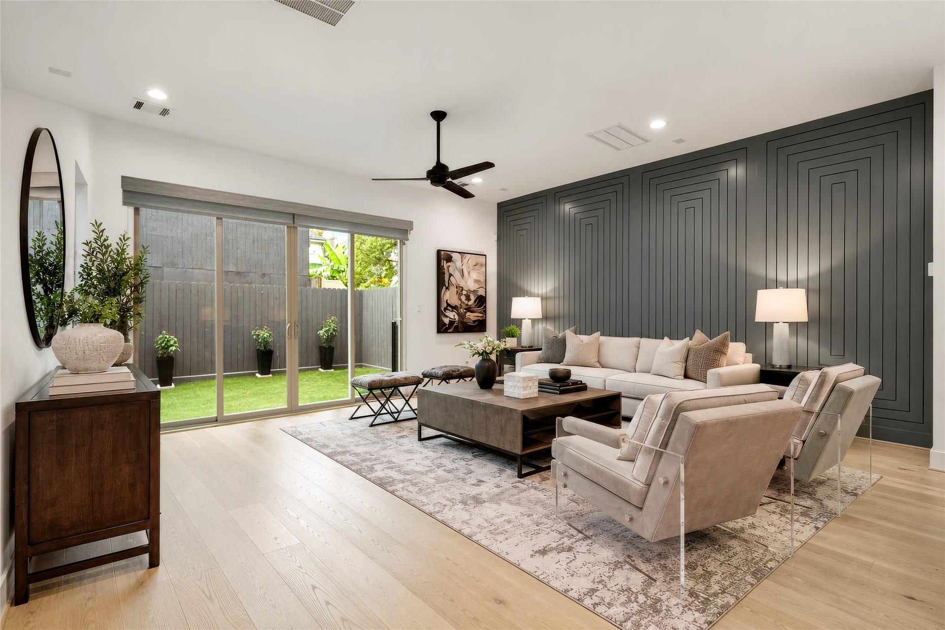2410 Elmen Street, Houston, TX 77019 Another perspective of the living room with sliding glass doors to the backyard. Amazing custom designer millwork on the North wall. Virtually rendered.