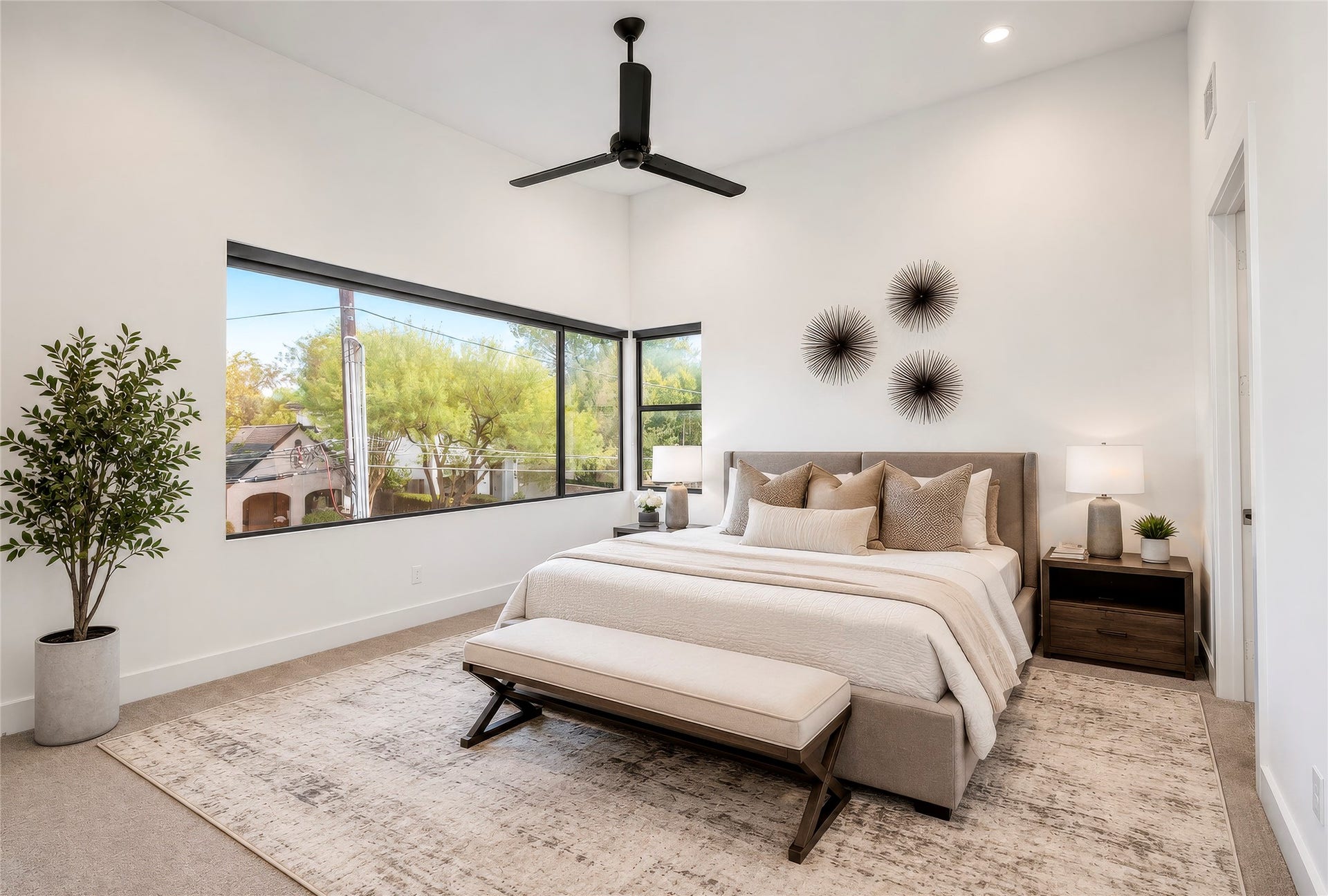 2410 Elmen Street, Houston, TX 77019 Welcome to the luxurious primary suite. High ceilings, ceiling fan, carpet - expansive windows with a view to the east towards downtown. Custom shades installed. Virtually rendered.