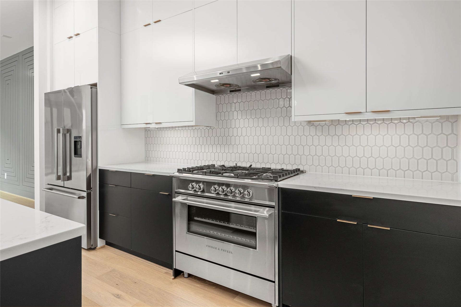 2410 Elmen Street, Houston, TX 77019 36" Fisher & Paykel free standing range and hood vent, with built in 36" french door refrigerator/freezer with pro handles and internal ice and external water. Gold finish cabinet hardware and soft close cabinets and doors.