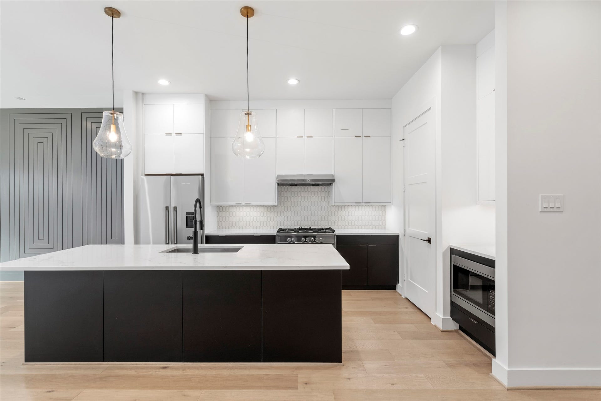 2410 Elmen Street, Houston, TX 77019 Chef's Kitchen with oversized island. Designer selected contrasting cabinetry with seasonal storage to the ceiling. Quartz counter tops.