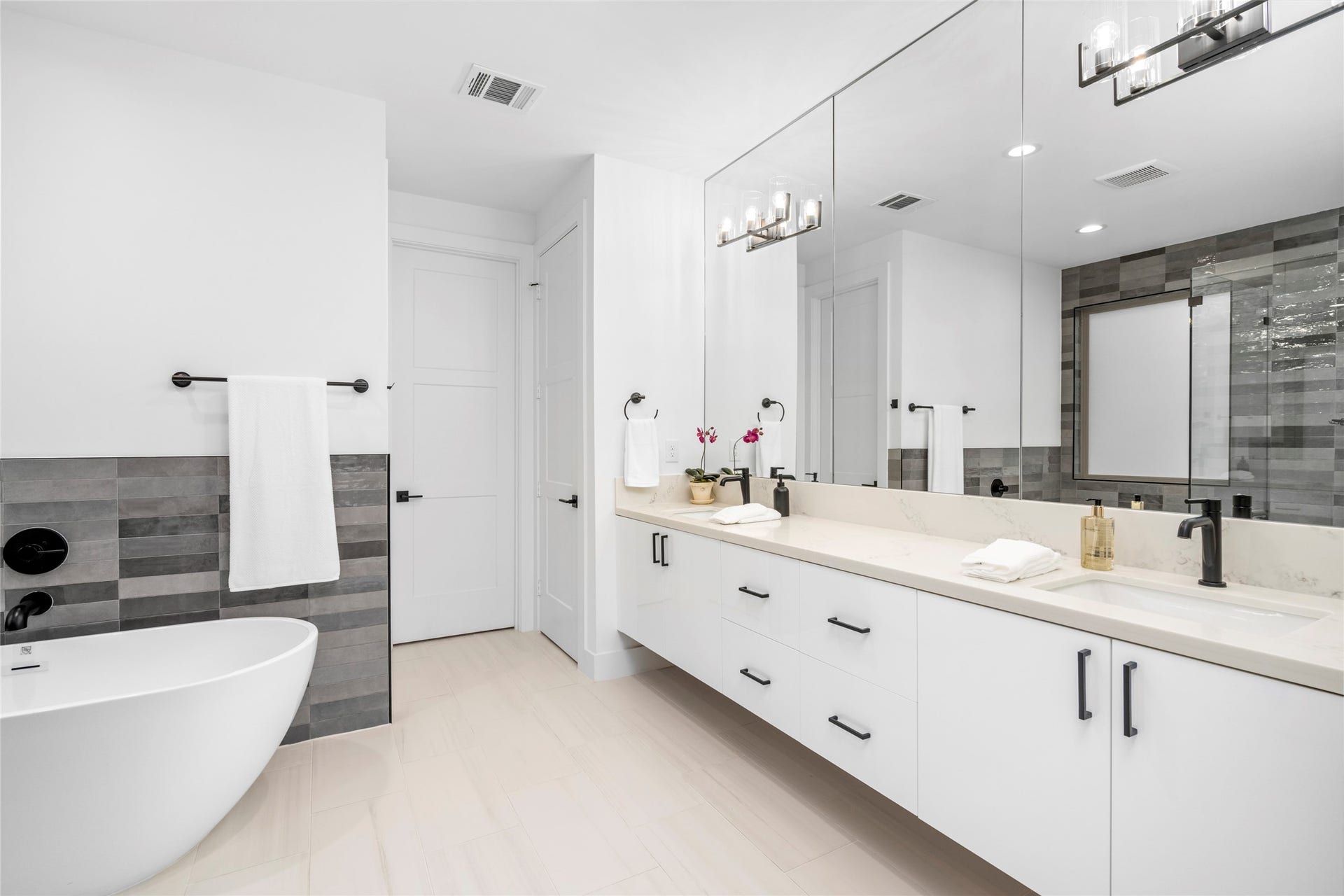 2410 Elmen Street, Houston, TX 77019 The primary bathroom has a freestanding soaking tub, full wall of mirrors with double floating vanities with quartz counter tops. So much cabinet and drawer storage.