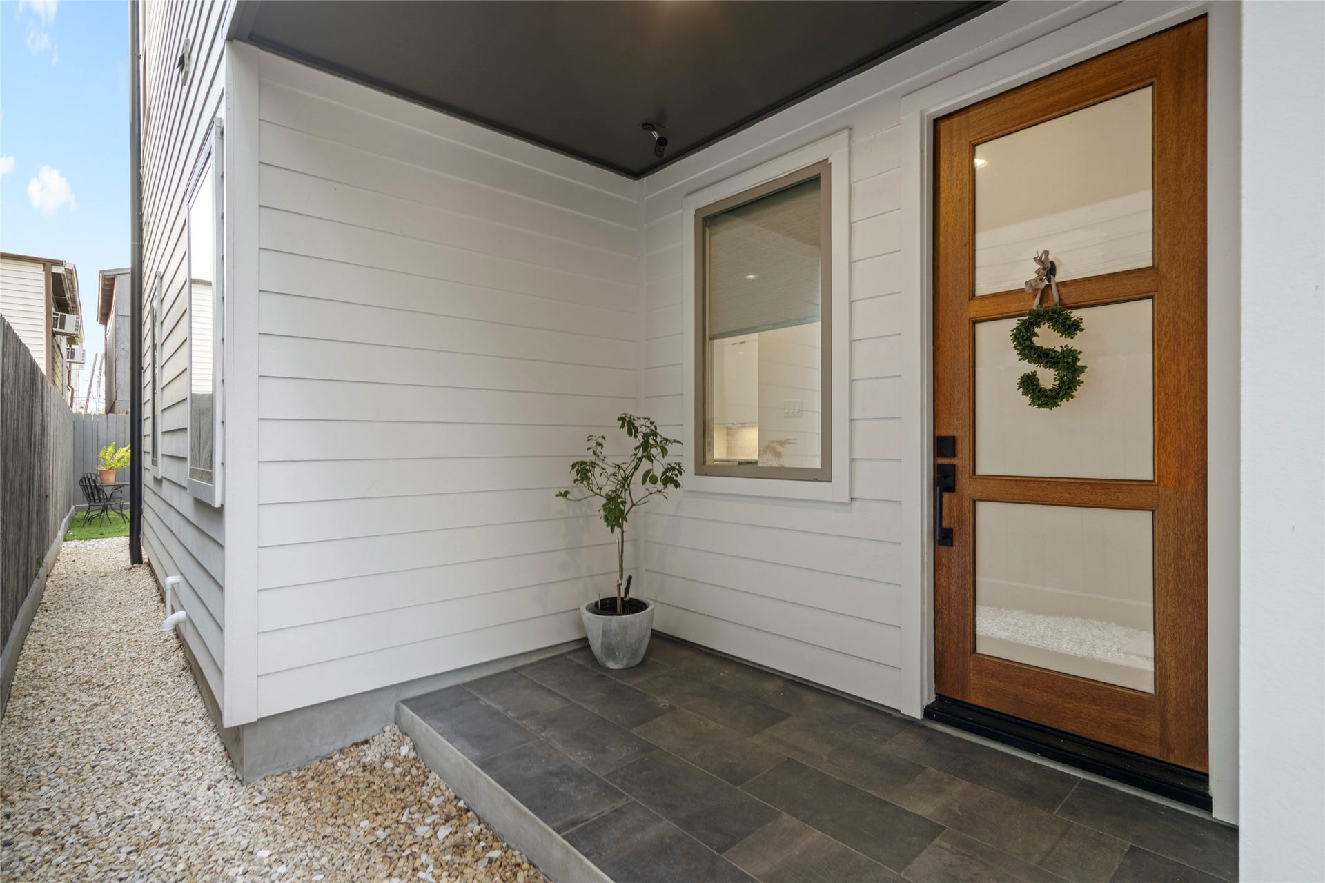 2410 Elmen Street, Houston, TX 77019 Welcoming covered Entry. Custom 3-lite mahogany stained front door. 12" x 24" porcelain tile in brick pattern. Low maintenance crushed limestone side yard.