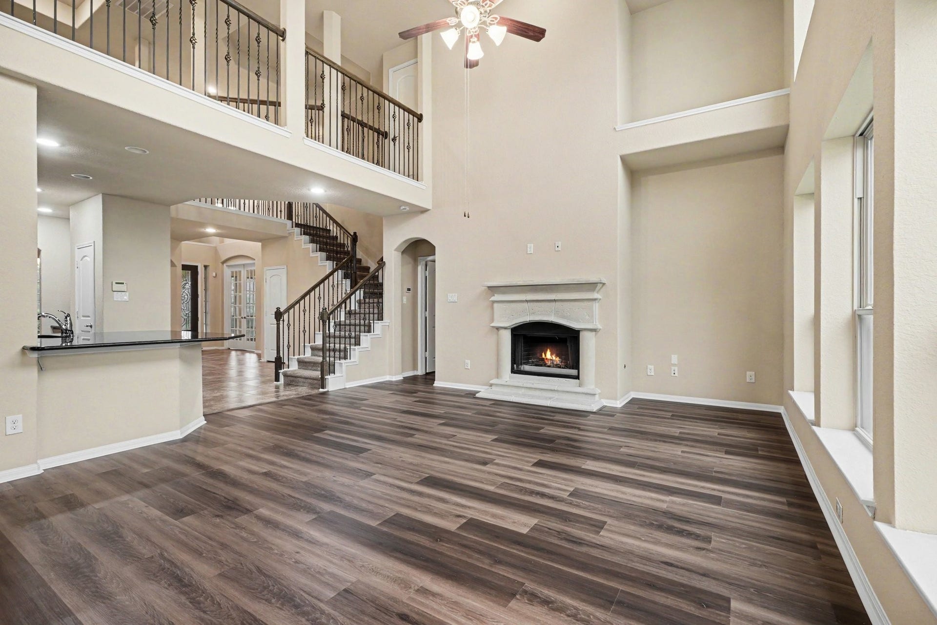 This FANTASTIC family room features a a gorgeous wrought iron and wood staircase with catwalk!