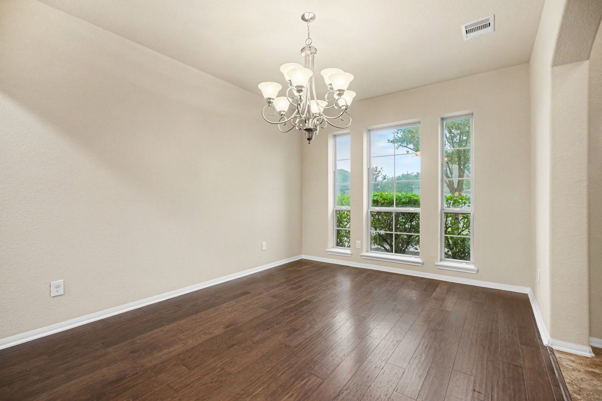 A beautiful chandelier anchors the space in this formal dining room with warm luxury vinyl flooring!