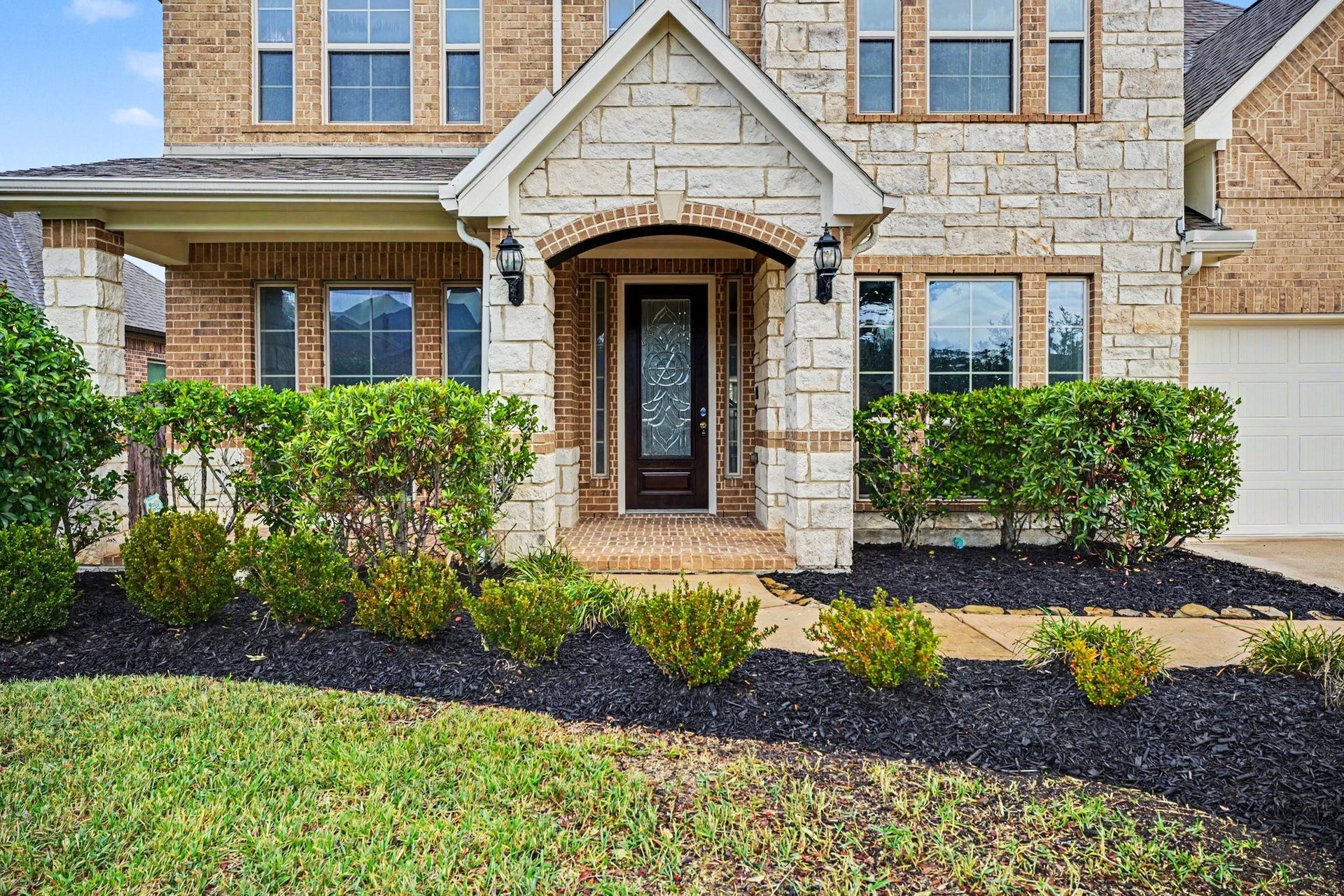 Pretty landscaping flanks the sidewalk and leads you to a covered front porch to sit and relax with your morning coffee.
