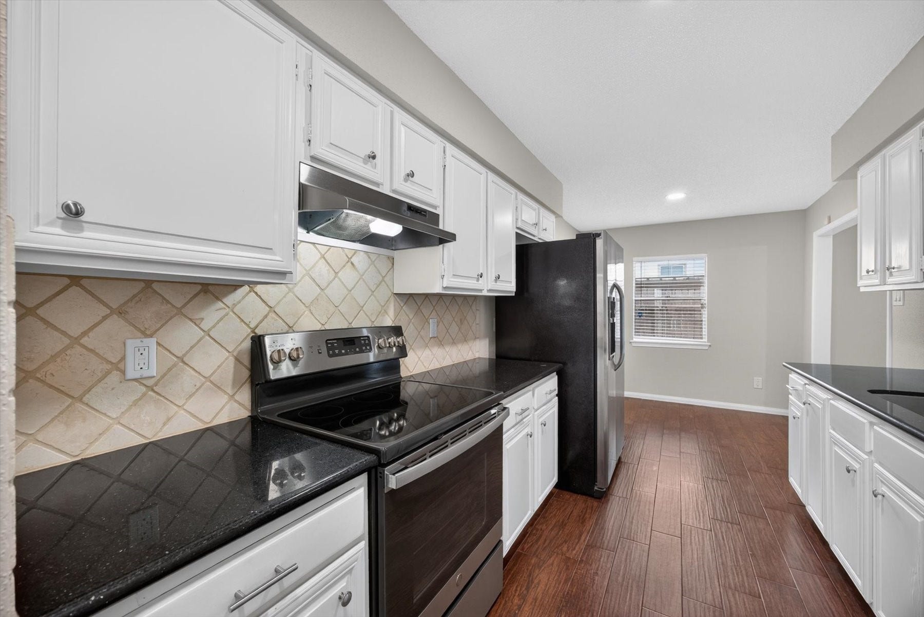 Electric range with granite counters offer plenty of cook space.