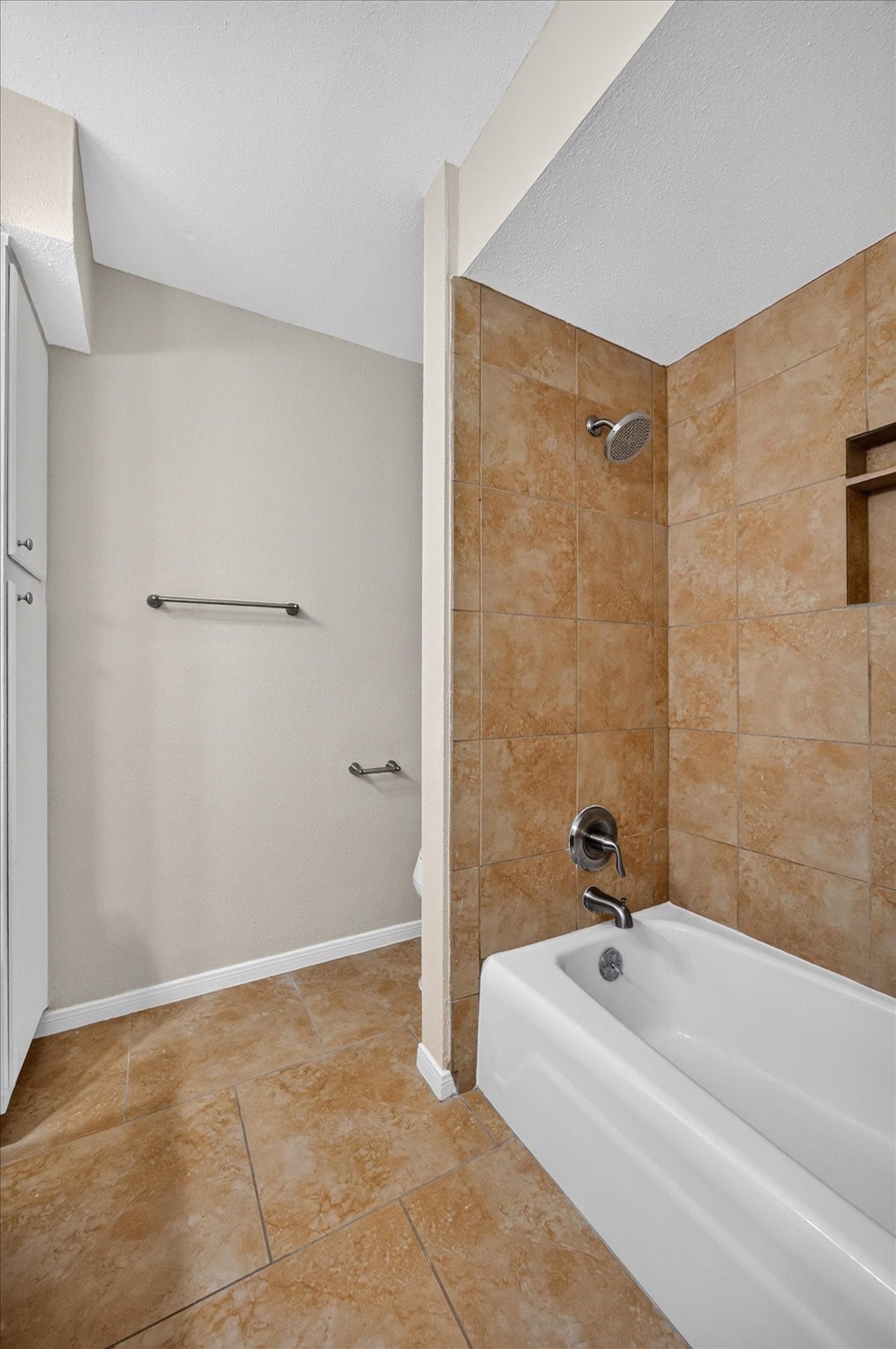 Primary bathroom features a tub/shower combo with tiled surround and fresh paint.