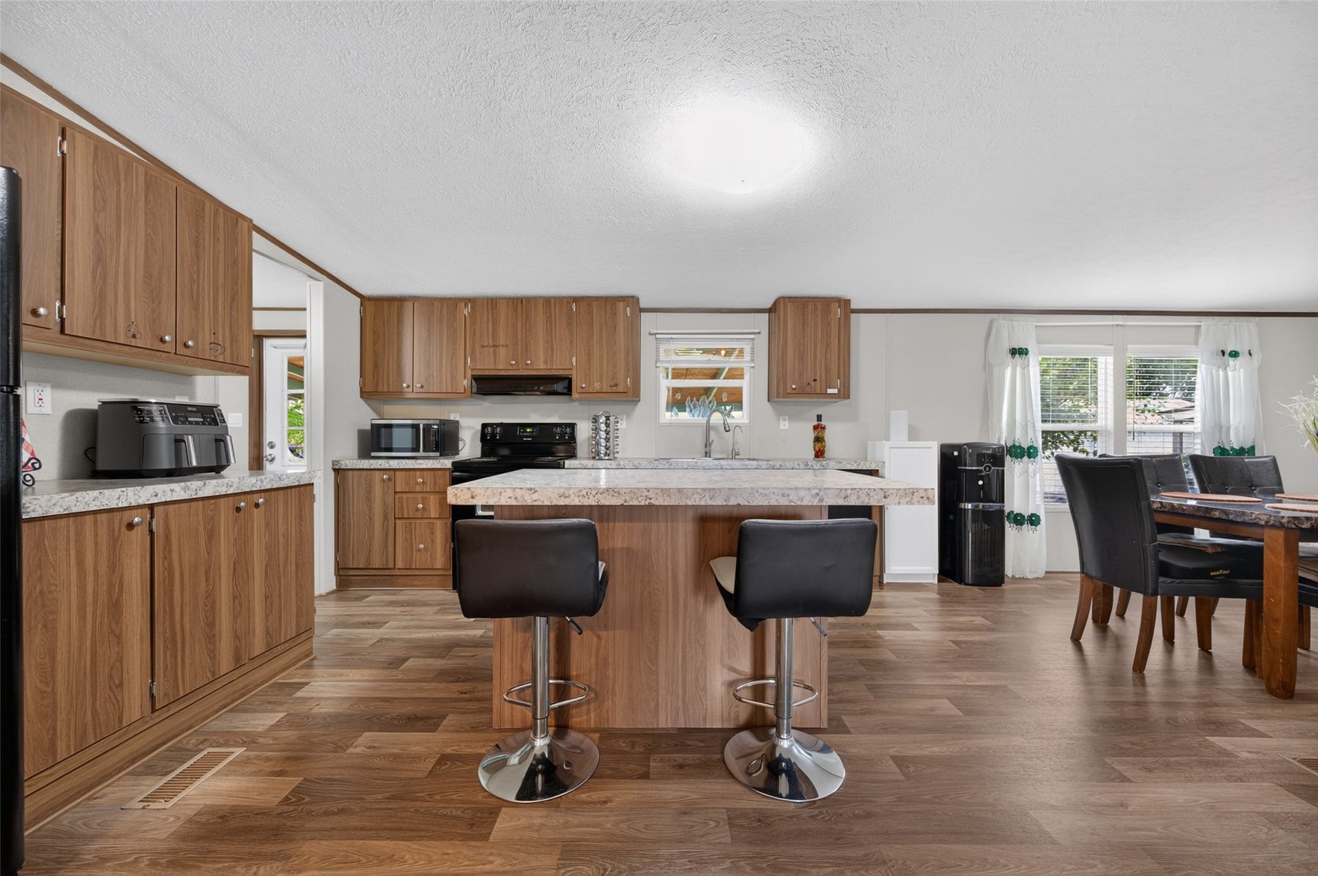 Eat-in kitchen island with bar seating and striking counters, with dining space just beyond