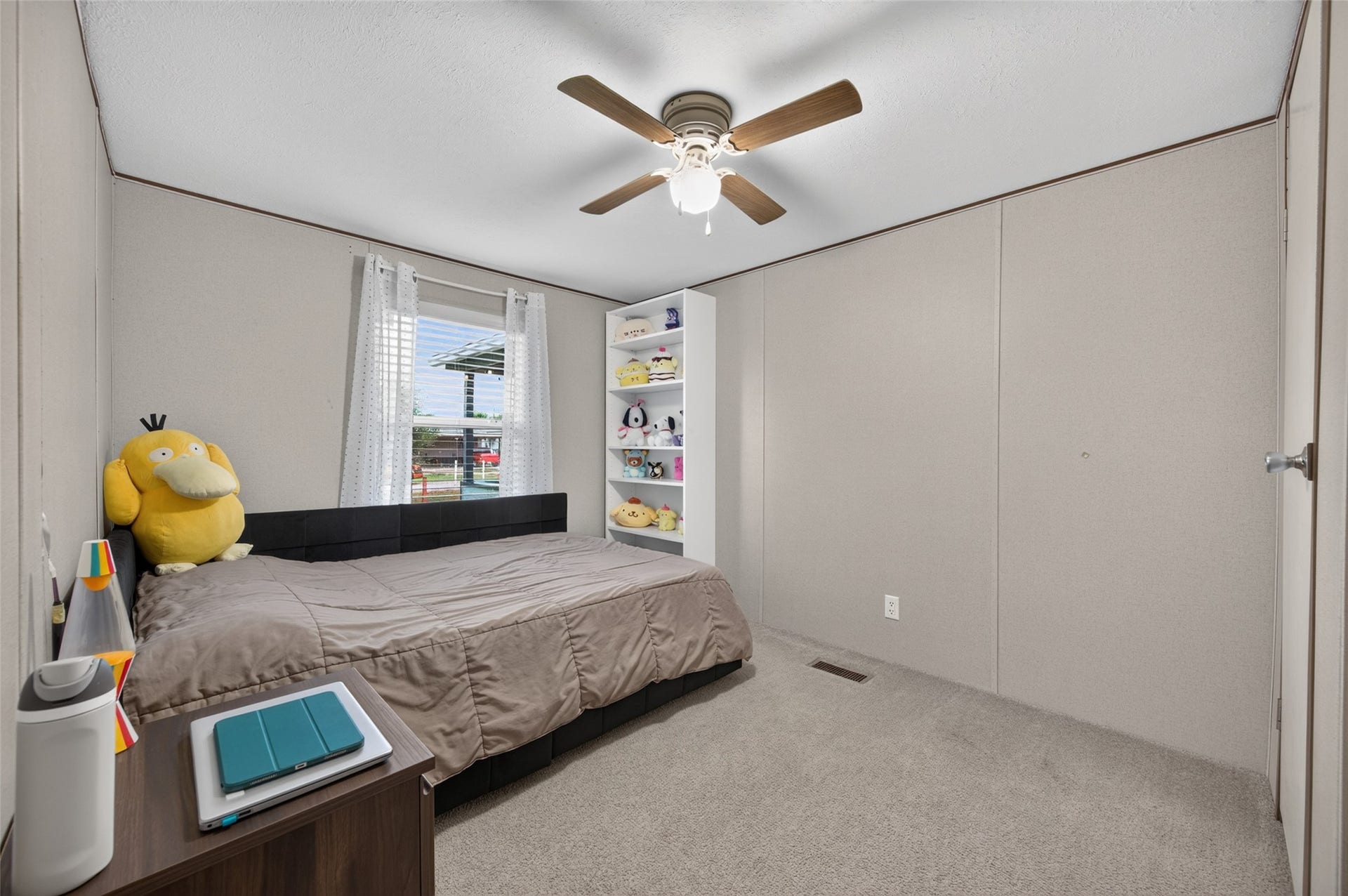 Comfortable secondary bedroom with ceiling fan and plenty of natural light
