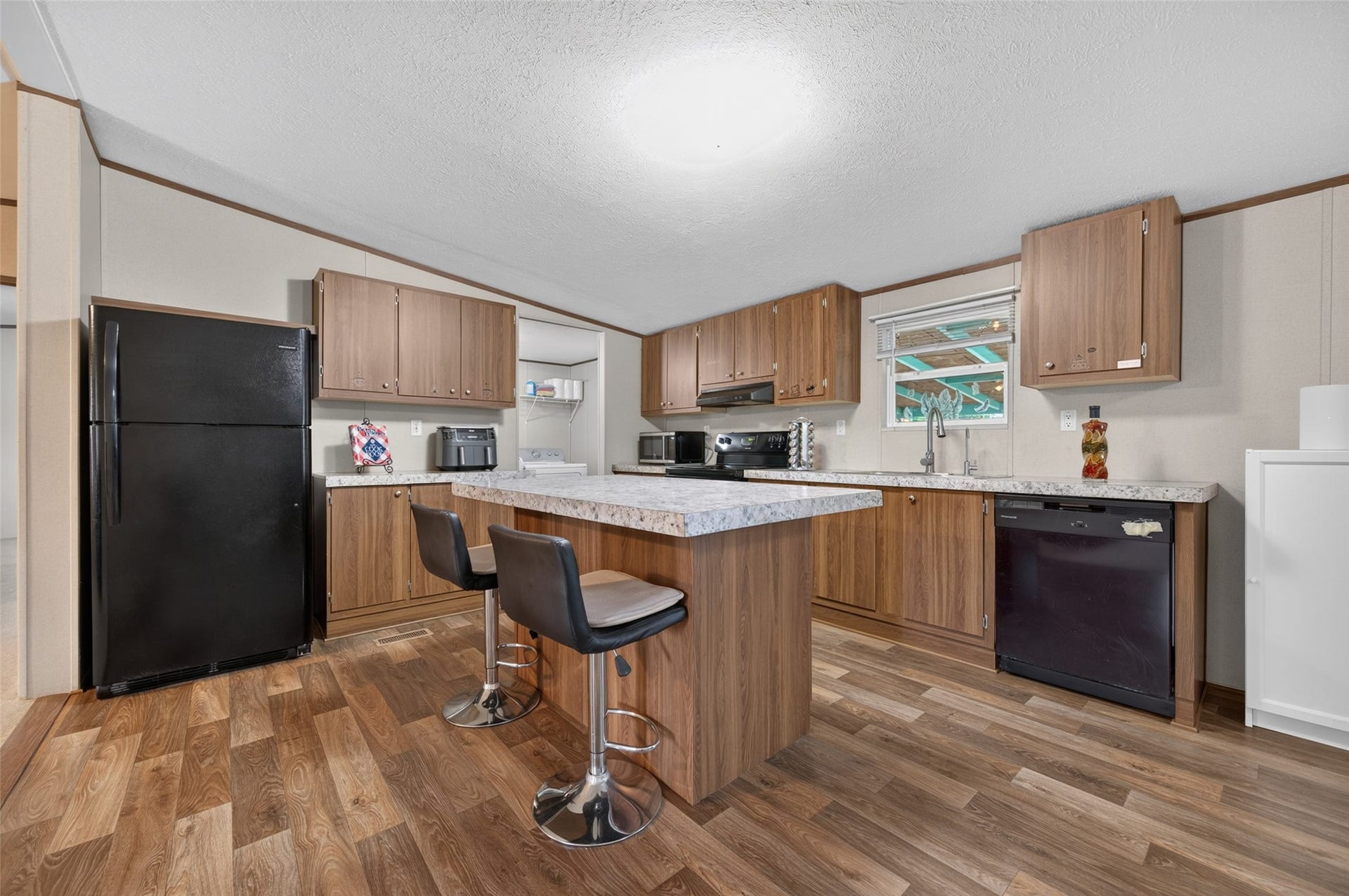 Well-equipped kitchen featuring a full-size refrigerator and dishwasher