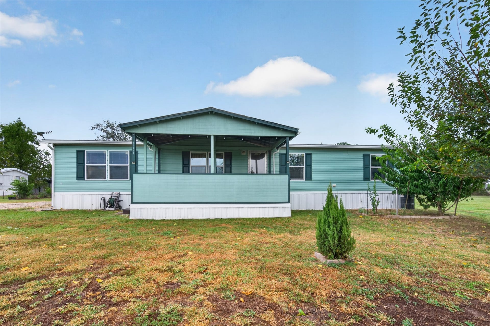 Front exterior view showing the home nestled on its expansive lot