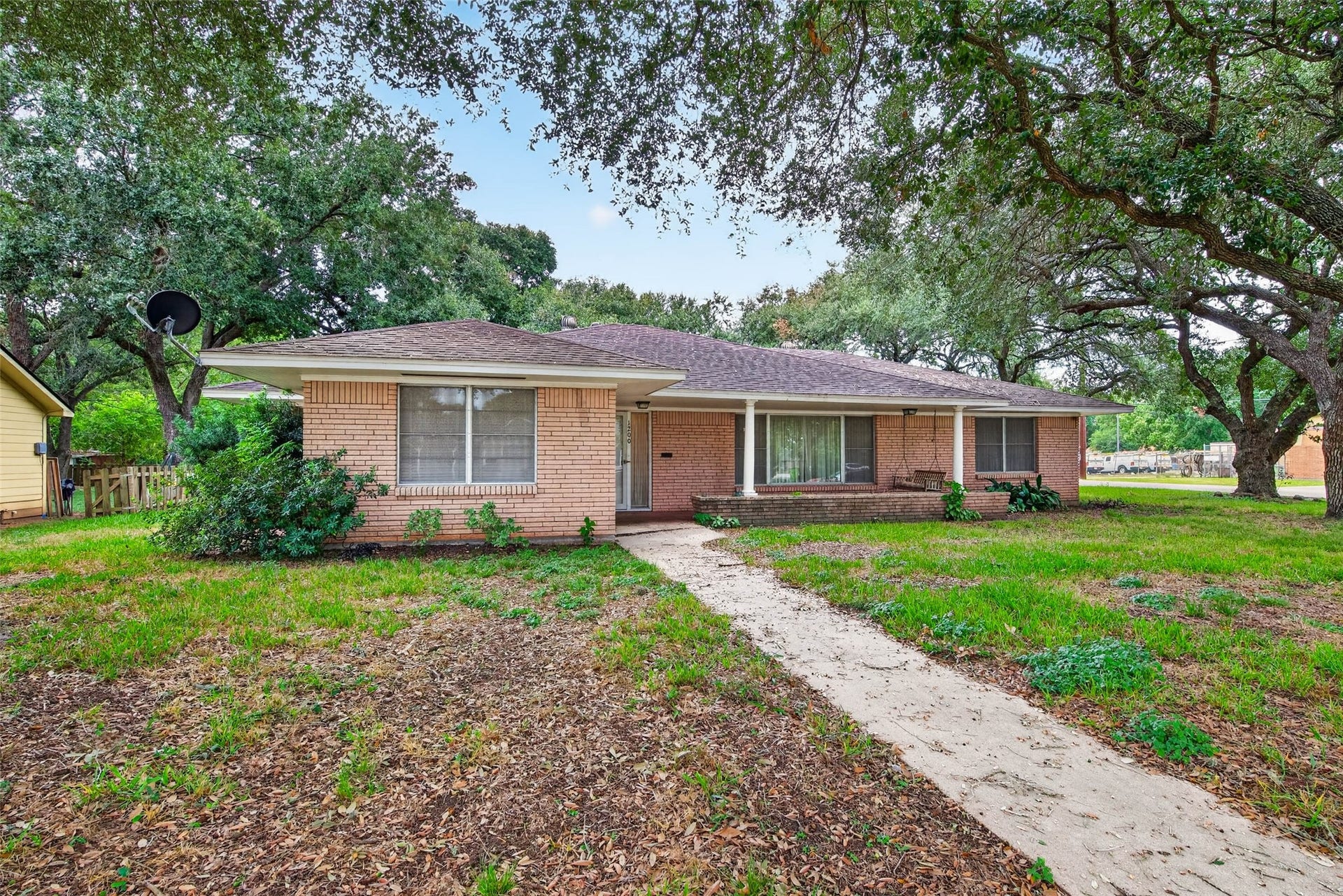 Front of the home surrounded by mature oak trees