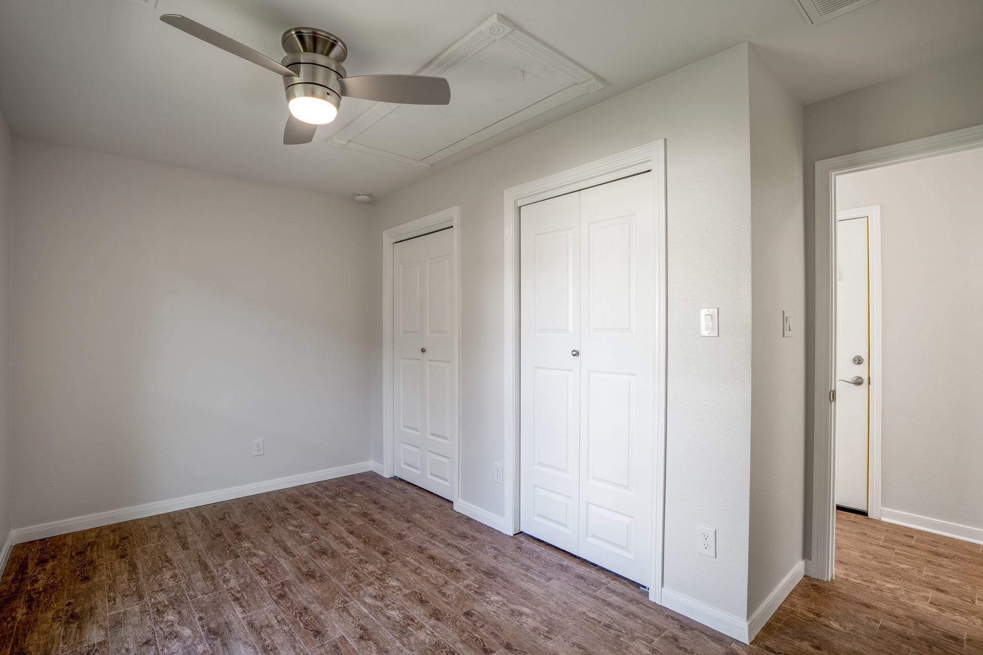 306 Foster Street, Tomball, TX 77375 Another angle of this bedroom reveals two closets, offering plenty of storage without taking up additional room space. Neutral walls & a modern ceiling fan complete the space, while the doorway to the right leads back into the hallway.