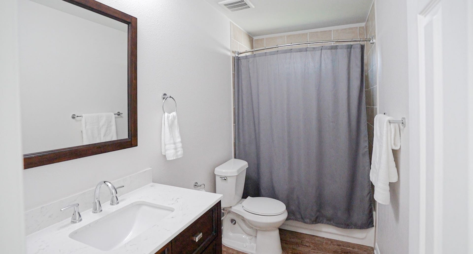 306 Foster Street, Tomball, TX 77375 Stepping into the primary bathroom, you'll find a dark wood vanity with a marble-look countertop, coordinating mirror & brushed nickel fixtures. Neutral tile surrounds the tub/shower combination, completing this ensuite bath.
