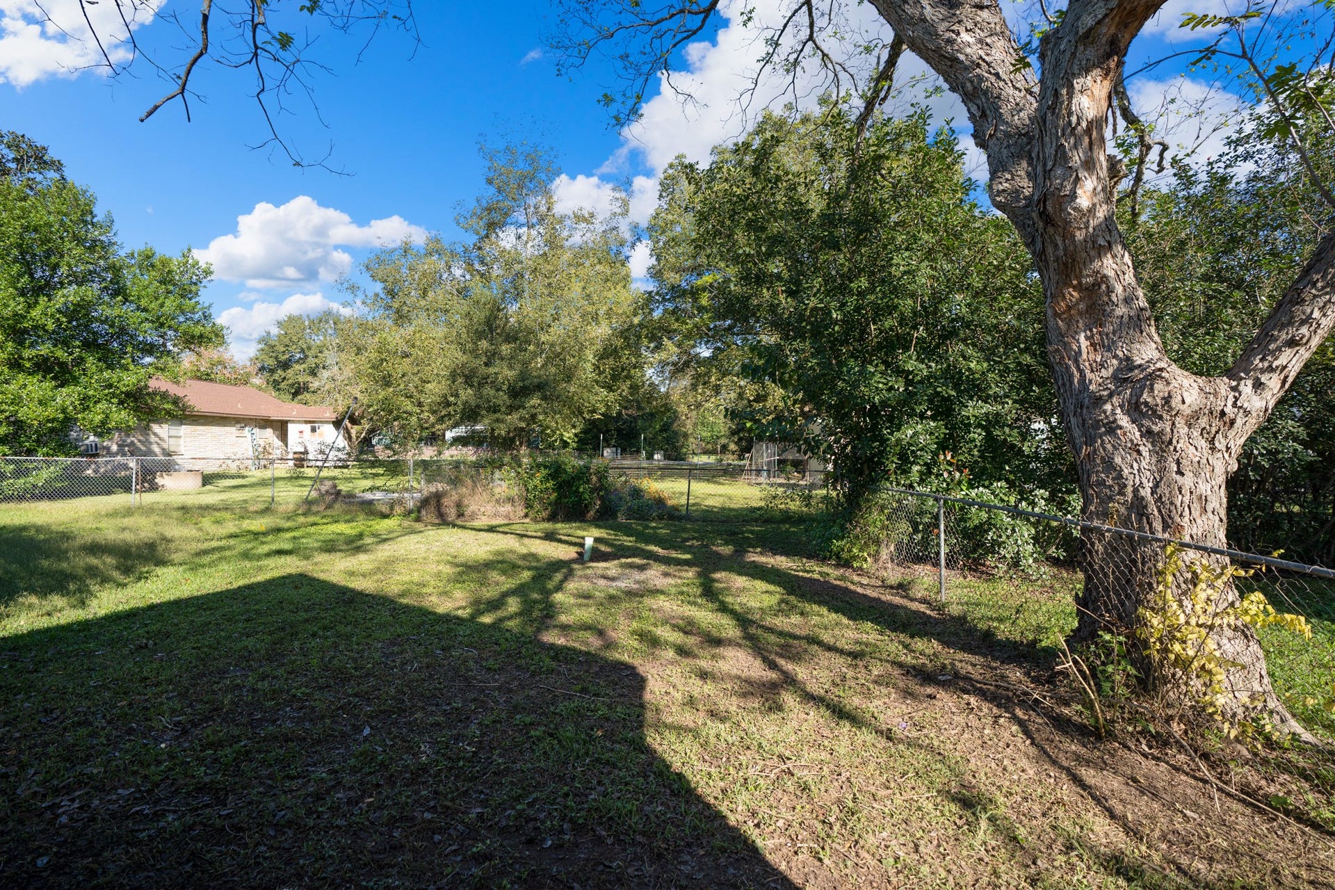306 Foster Street, Tomball, TX 77375 Looking out from the back deck, the spacious backyard offers plenty of room to enjoy the outdoors! Mature trees provide welcome shade, while the grassy yard leaves room for outdoor seating, lawn games or simply relaxing in your own backyard.