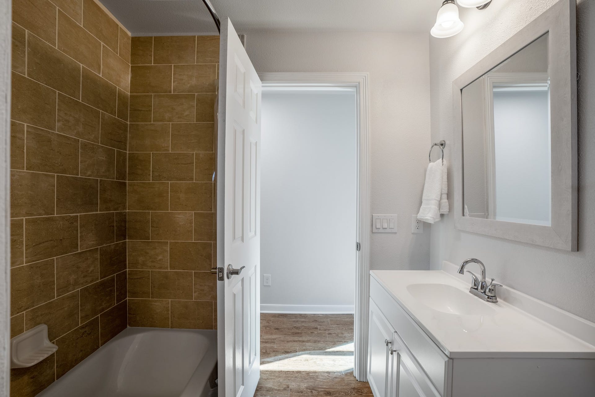 306 Foster Street, Tomball, TX 77375 Another look at the secondary bathroom highlights the tub/shower combination with floor-to-ceiling tile, a white vanity & coordinating fixtures. Through the open door, well head back into the hallway to continue touring the bedrooms.