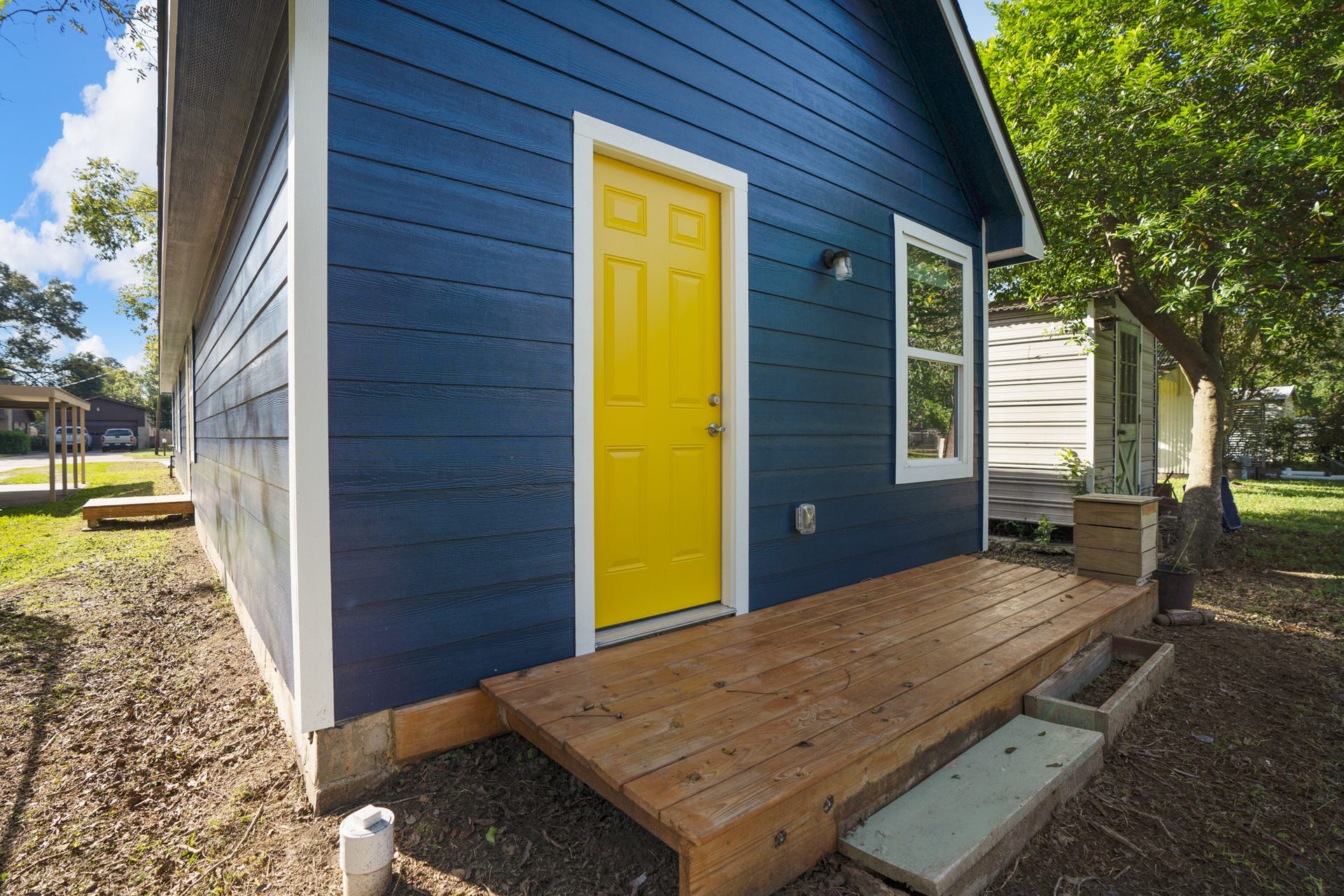 306 Foster Street, Tomball, TX 77375 Just outside the primary bedroom, a raised wooden deck offers room for a couple of chairs & a spot to enjoy your morning coffee or unwind outdoors. The cheerful yellow door opens directly into the primary suite, providing easy access to the backyard.