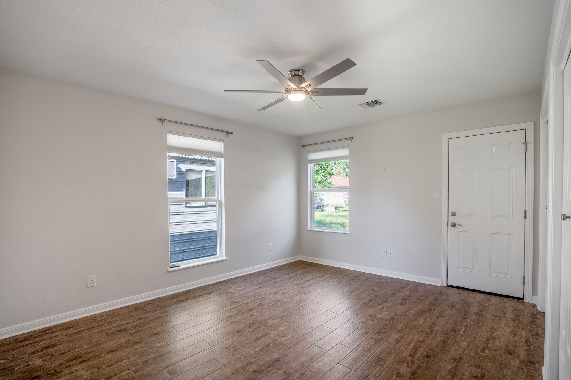 306 Foster Street, Tomball, TX 77375 At the end of the hallway, the primary bedroom offers plenty of natural light from two windows overlooking the side & backyard. A modern ceiling fan complements the neutral walls, while the door straight ahead provides direct access to the backyardperfect for stepping outside with your morning coffee!